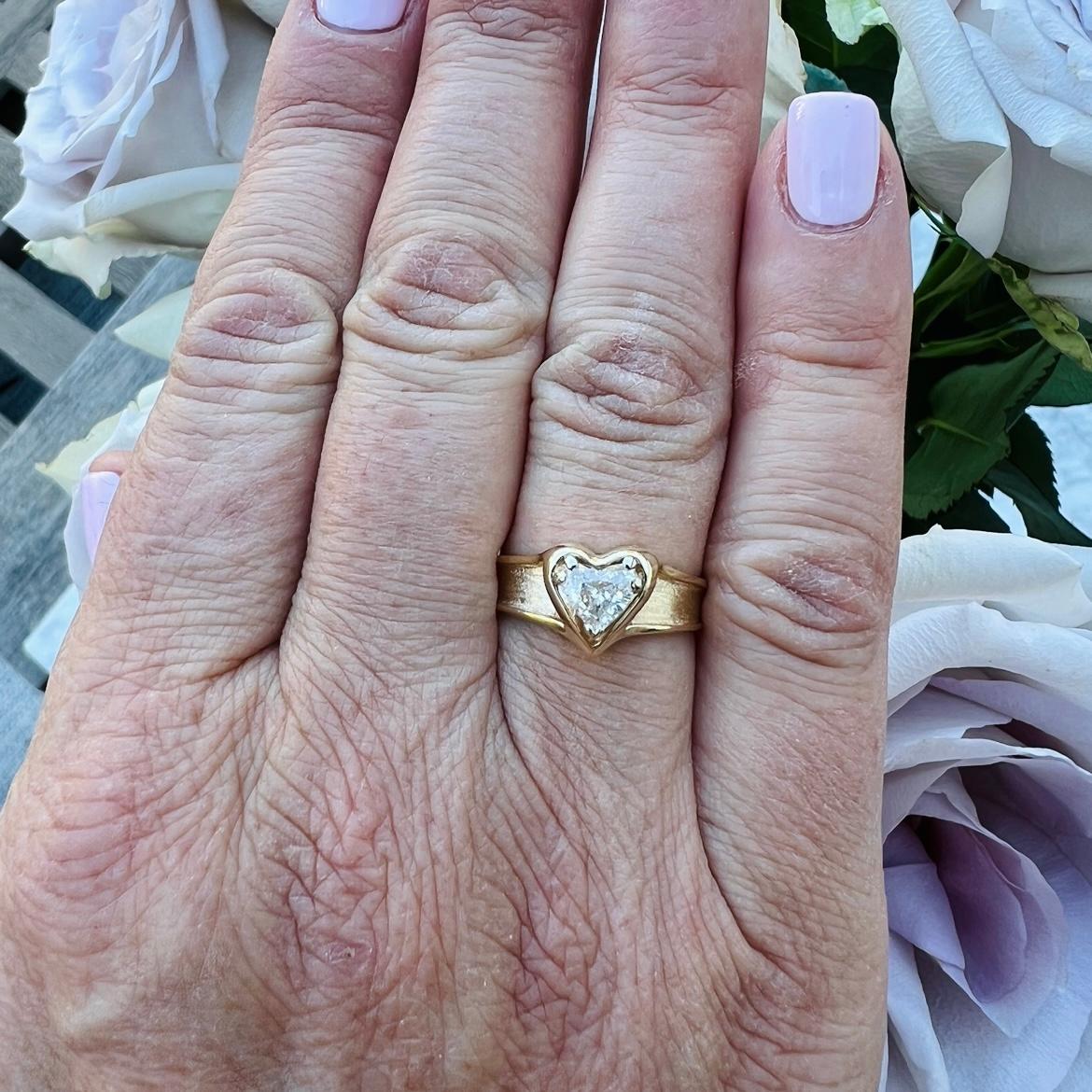 Love is in the air! With this 14k gold engagement ring, express your love with a heart-shaped diamond weighing approximately .58-ct., and graded G-H color and VS-SI. Set in a polished heart frame with a tapering satin band, the ring harks back to