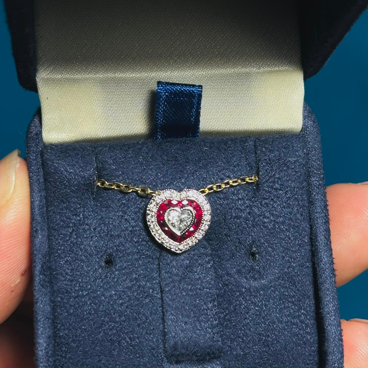 Realizzato in oro bianco 14 carati, questo delizioso ciondolo a forma di cuore offre una splendida combinazione di raffinatezza e fascino. I diamanti centrali a forma di cuore pesano 0,25 carati e hanno un colore G e una purezza VS. Una cornice di