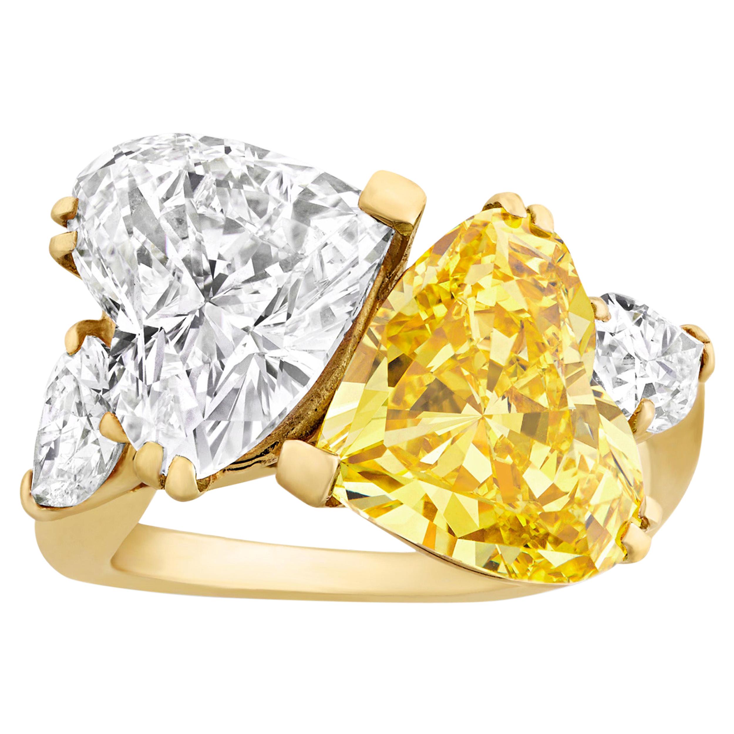 Two captivating heart-shaped diamonds intersect in this ring from the House of Cartier. The first, an extraordinary 3.02-carat natural fancy vivid yellow diamond with VVS1 clarity, glistens with the radiance of pure sunshine, while the other, a