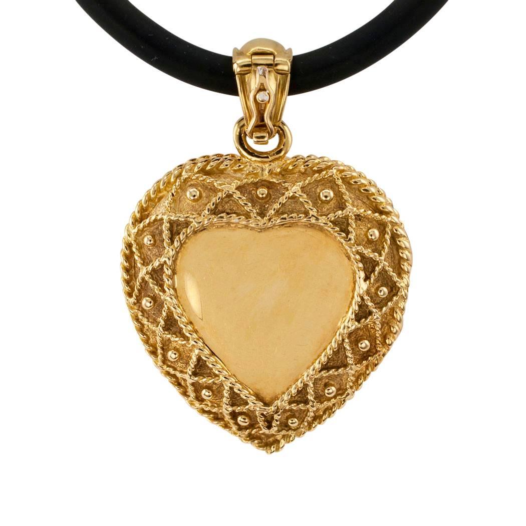 Estate 1990s heart-shaped diamond and gold locket. The hinged locket design features a heart-shaped plaque pavé-set with diamonds, within a conforming border of crisscrossing corded gold accented with round gold studs, to the enhancer bail similarly