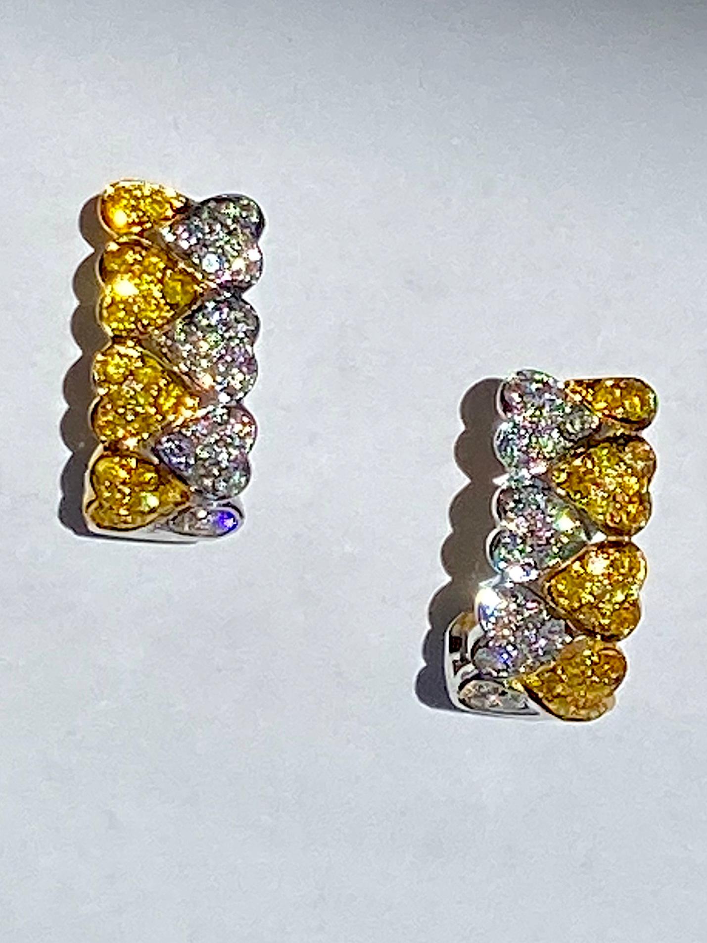 Heart Shaped Diamond Hoop Earrings with .52 carats of brilliant round cut diamonds all F-G color and VS clarity. The opposite side has .54 carats of Fancy Yellow brilliant round cut diamonds set in 18 karat white and yellow gold, pavé set.  These