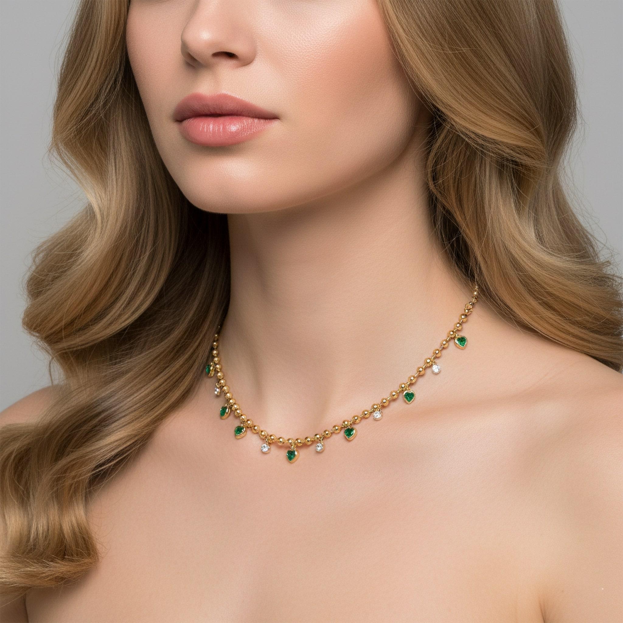 Le collier de perles de diamants en or jaune 14K en forme de cœur d'émeraude est un mélange vibrant de couleurs et d'élégance. Réalisée en or jaune 14 carats, cette magnifique pièce est ornée d'émeraudes (0,95 carats), de rubis et de diamants pleine