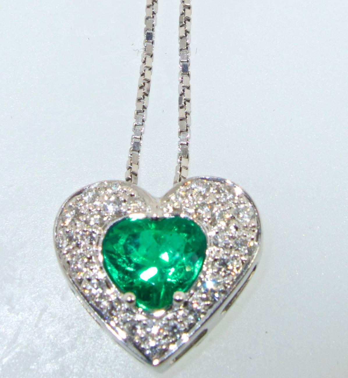 The heart shaped center natural Emerald is a bright lively green which is surrounded by fine white diamonds.  The Emerald weighs approximately .85 cts., and the fine white diamonds (H,VS1), weighs approximately .33 cts.  The 18K white gold pendant