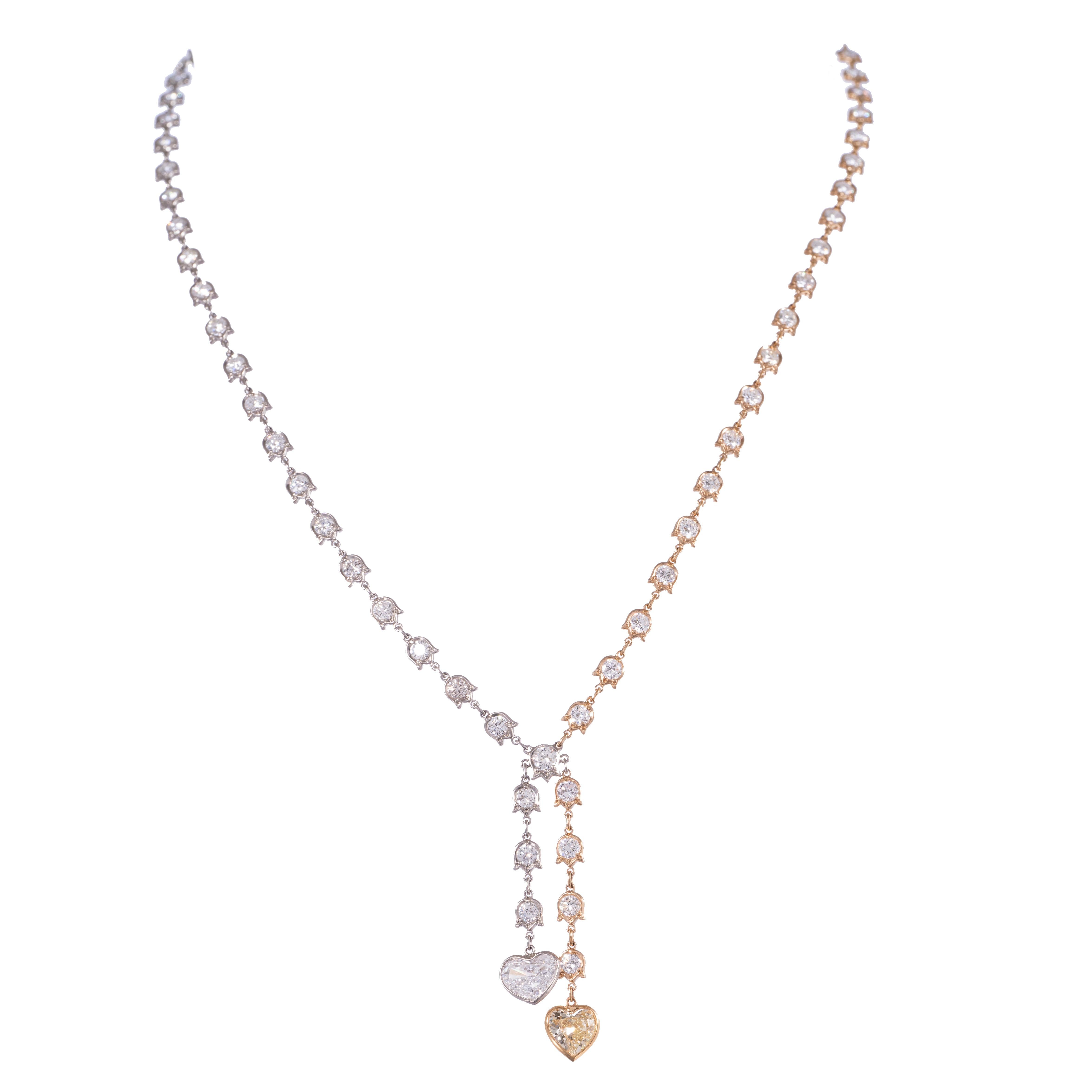 Un bellissimo mix di stile classico con un tocco contemporaneo: ecco una collana di diamanti unica e alla moda. La collana è disegnata intorno a una coppia di diamanti a forma di cuore, uno giallo e l'altro bianco. L'idea della collana ha portato a