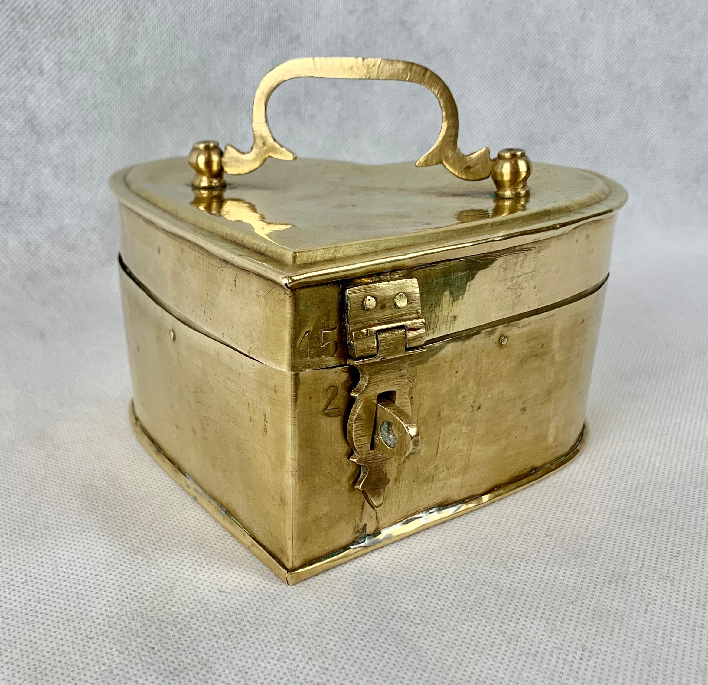 Interesting heart shaped hinged box in brass with a dfold down handle.  What makes it interesting is that it is obviously handcrafted.
Measures: Height-3 1/2