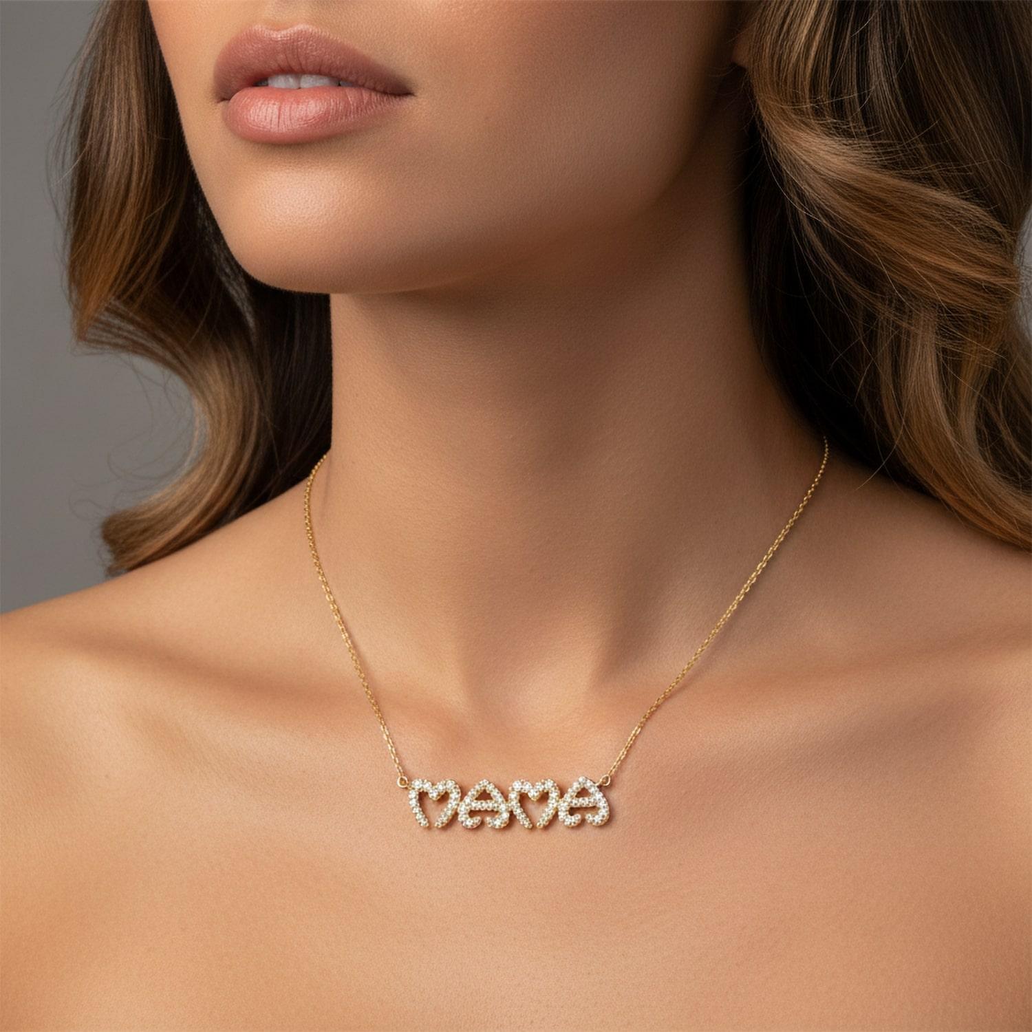 Diese wunderschöne MAMA-Halskette in Herzform aus 14K Gold ist eine zeitlose Hommage an die Mutterschaft. Mit seinen funkelnden natürlichen Diamanten in einem zarten Design ist er perfekt, um die starken Frauen in Ihrem Leben zu feiern. Ob täglich