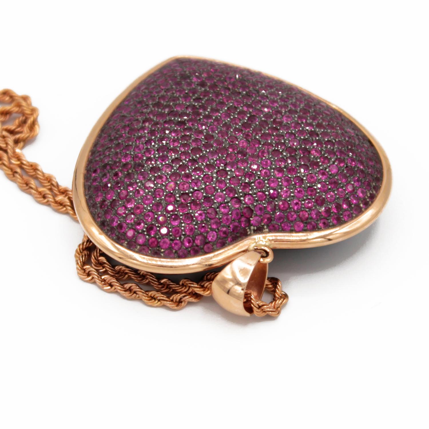 Pendant necklace realized in : Rubies pave on silver setting, Bakelite back and 18kt pink gold. 
Heart size : 45 x 42 mm 
Rubies ct. 9,3 on silver setting and bakelite back part
Gold g. 6
18kt pink gold chain g. 2,9. Lenght 50 cm. 
Total weight