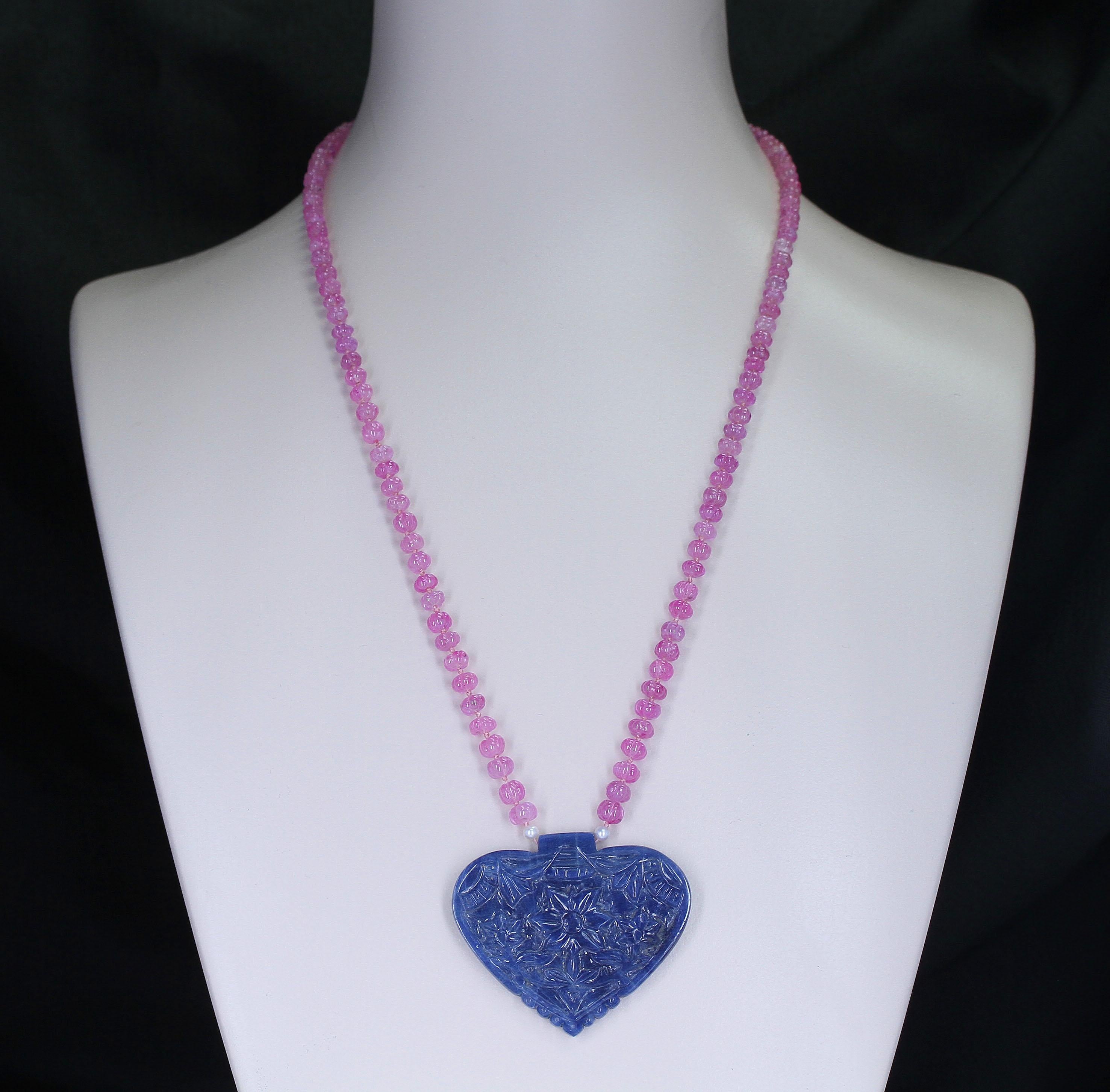 A large blue, no-heat and natural heart-shaped sapphire carving with Pink Sapphire Carved Beads. Stamped 585, Total Weight: 326 carats, Sapphire Carving: 150 cts., Pink Sapphire Beads: 171 cts., Total Length without carving: 25 Inches, Beads: 5 MM