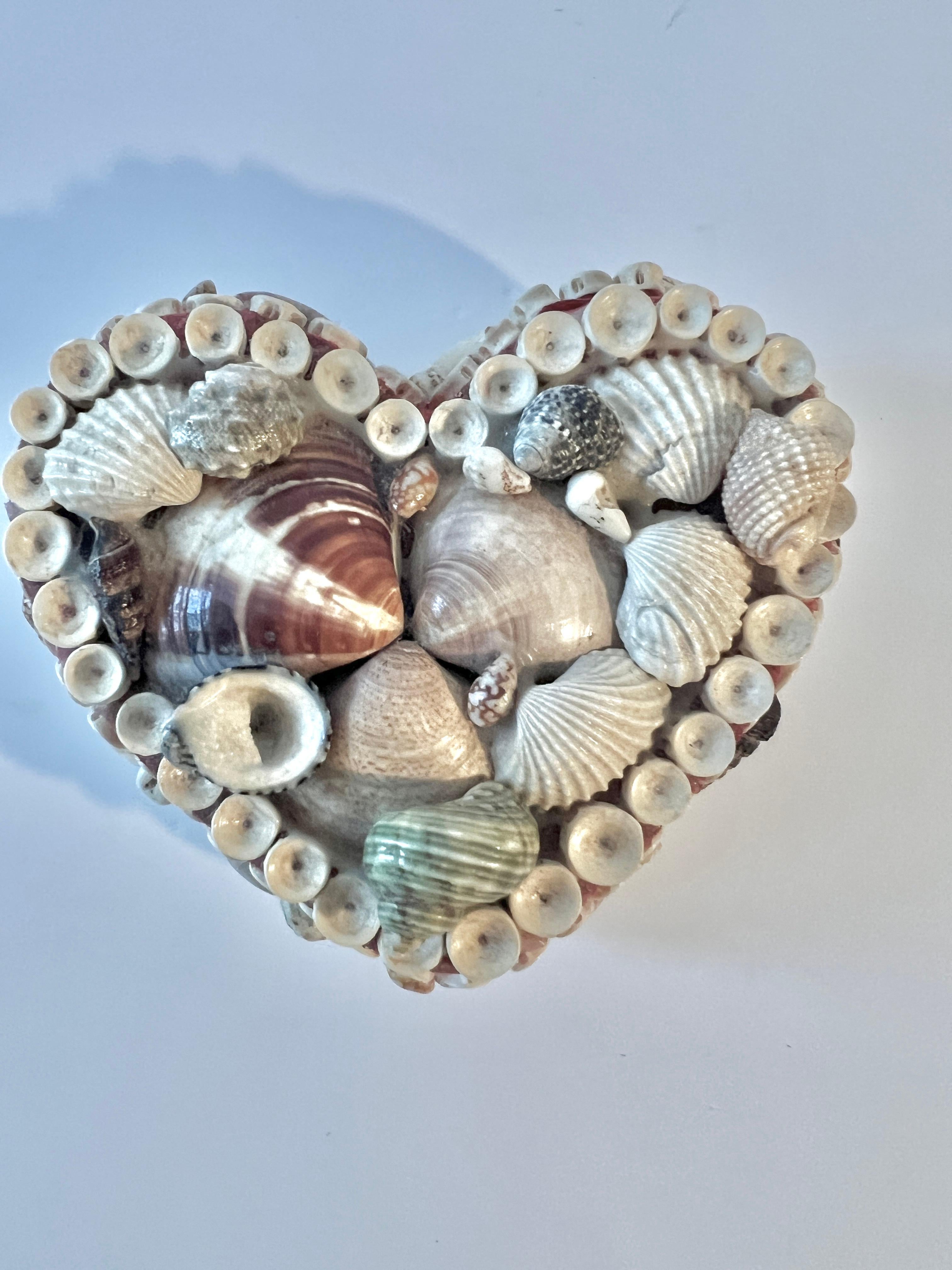 A hand crafted Sea shell box in a heart shape.  The box is hinged and opens with a brass chain to hold open.  Lined in red felt.

A great gift, wedding or birthday - the box is a compliment to the side table, dressing table, or vanity.  A nice