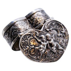 Heart-shaped silver pill box with embossed angel decoration on the hinged lid