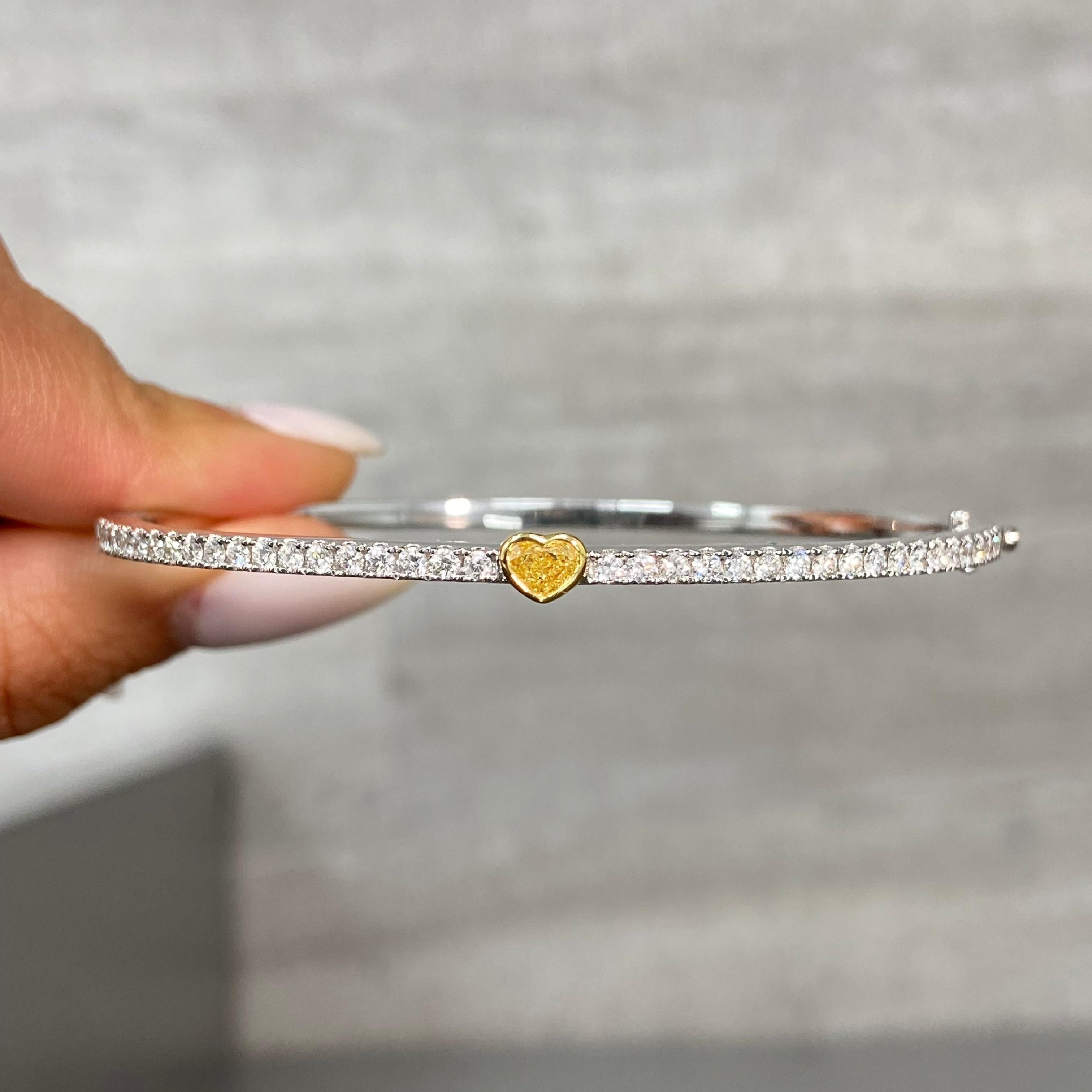 1.10 Carats Total 
0.88 Carat Light Yellow Heart Shape Diamond 
0.38 Carats of White Round Diamonds
SI-VS1 Clarity 
Size 7 Wrist
Crafted in 18k White & Yellow Gold 

At Rare Colors, you can experience the elegance of our exquisite fancy colored