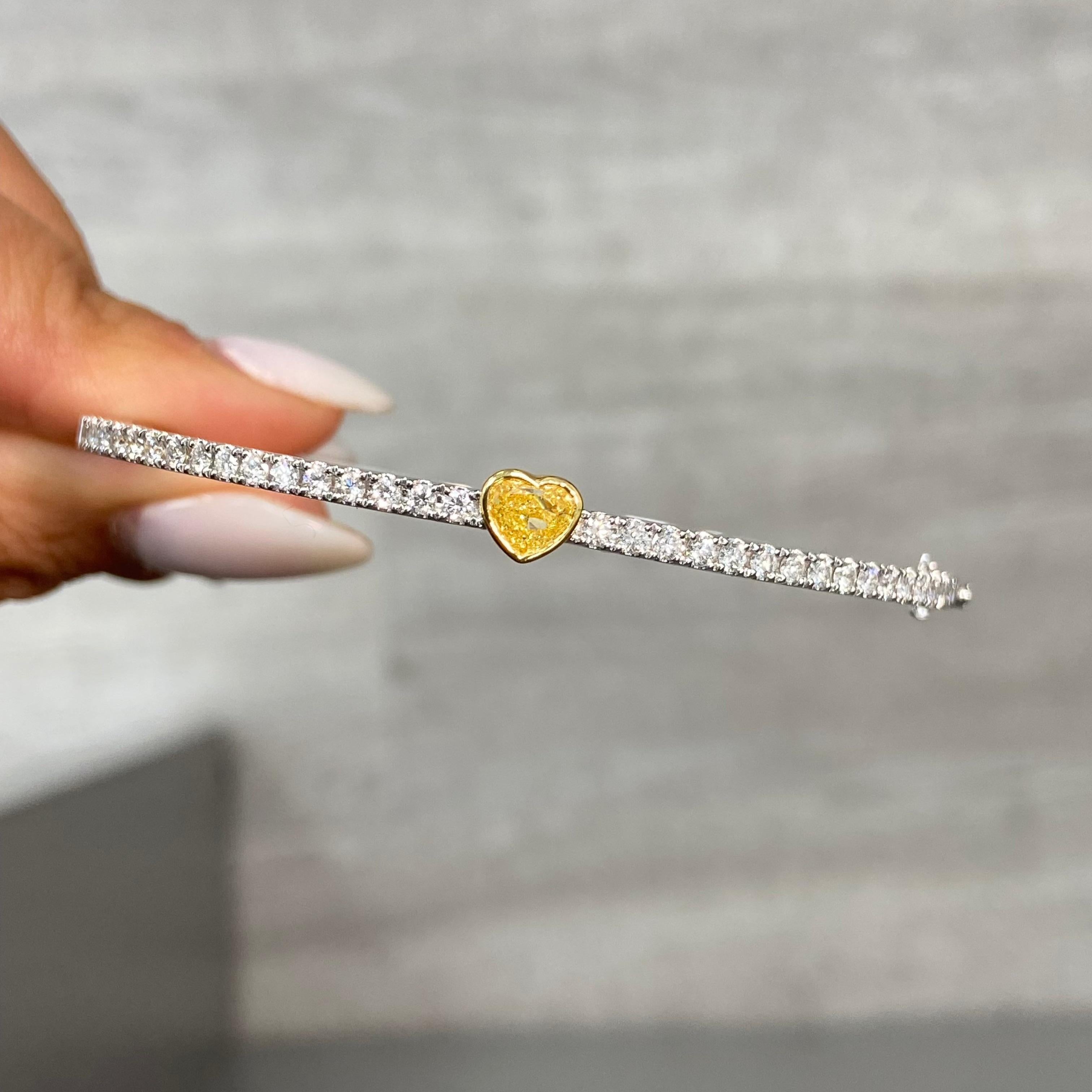 1.31 Carats Total 
0.91 Carat Light Yellow Heart Shape Diamond 
0.34 Carats of White Round Diamonds
SI-VS1 Clarity 
Size 7 Wrist
Crafted in 18k White & Yellow Gold 

At Rare Colors, you can experience the elegance of our exquisite fancy colored