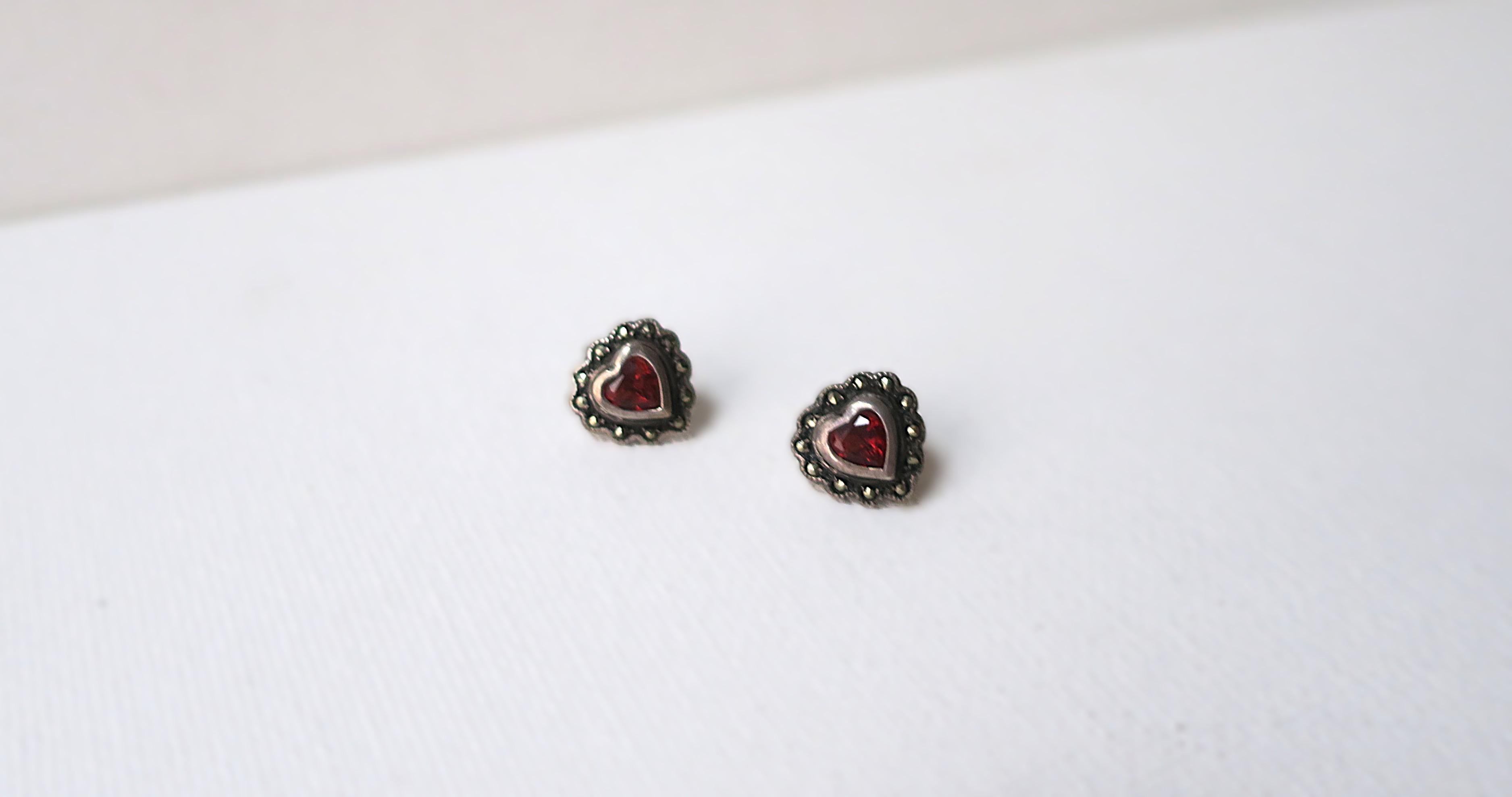 A pair of 'Heart' sterling silver and red stone stud earrings. Both marked on back '925 Sterling'.