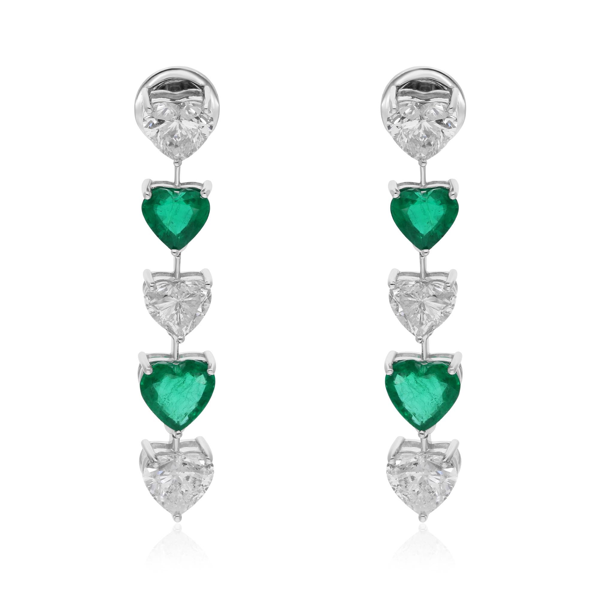 At the center of each earring dangles a mesmerizing heart-shaped Zambian emerald, renowned for its rich green hue and exceptional clarity. Sourced from the prestigious mines of Zambia, these emeralds exude an aura of luxury and sophistication,