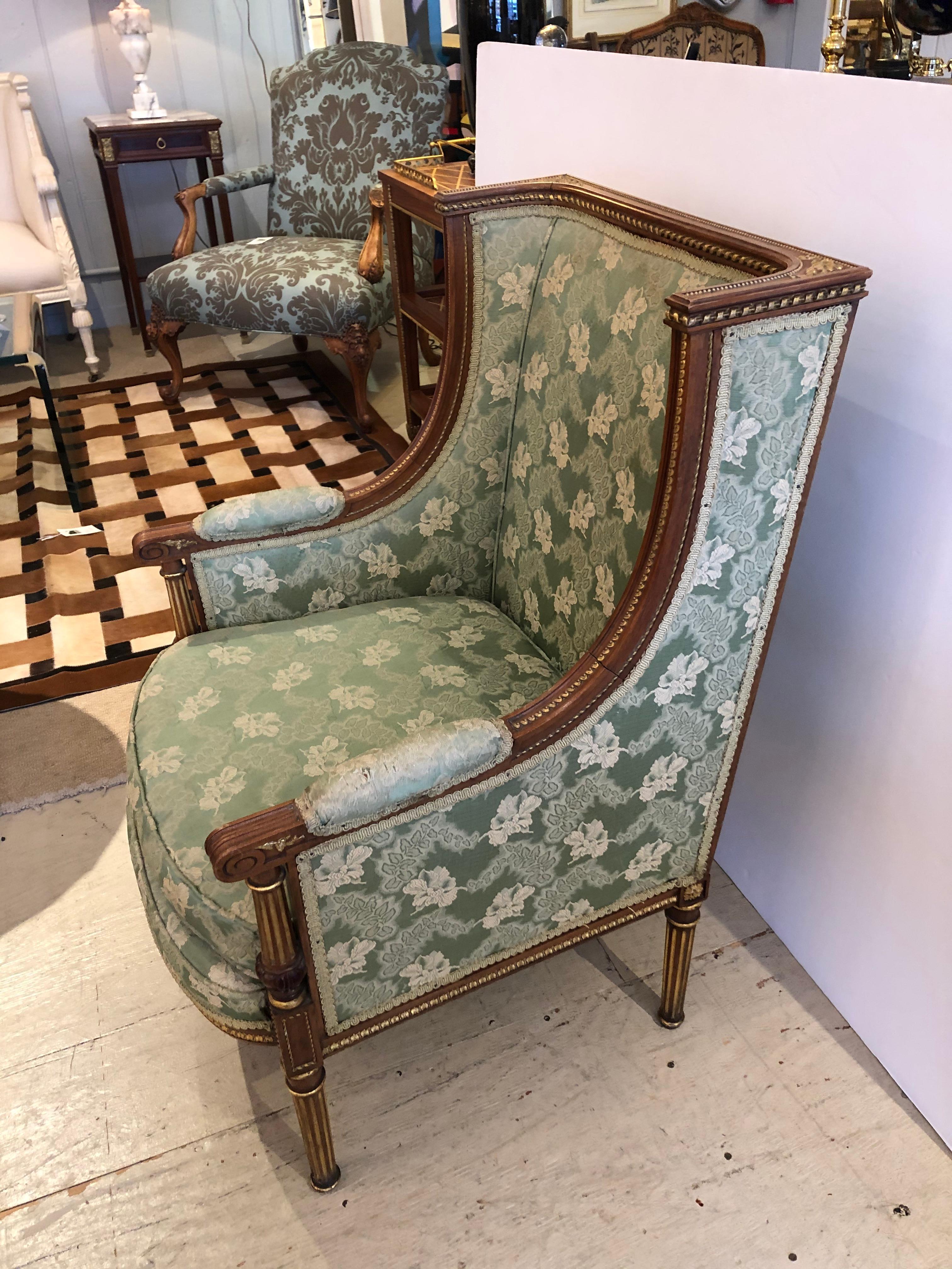 An utterly sublime French Louis XVI style bergère sized for a princess having gilded carved walnut frame with magnificent detailing, reeded legs, and original green satin brocade. Upholstery shows some wear especially on the arm pads.
Measures: Arm