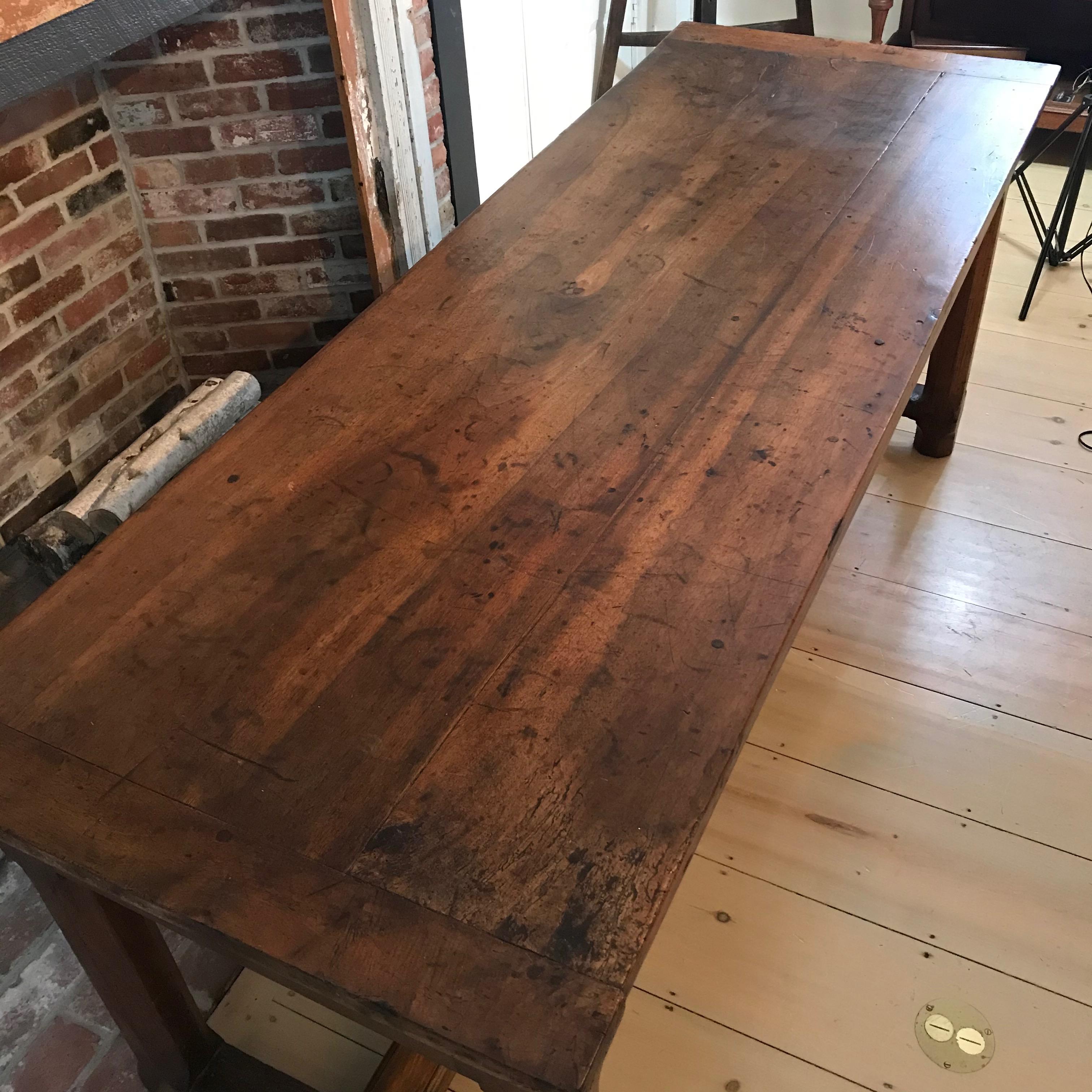 A spectacularly aged walnut farmhouse table from Southern France having a marvelous solid thick top, canted corners and breadboard ends. A large end drawer resides in the table’s apron, allowing for unexpected and convenient storage. The robust