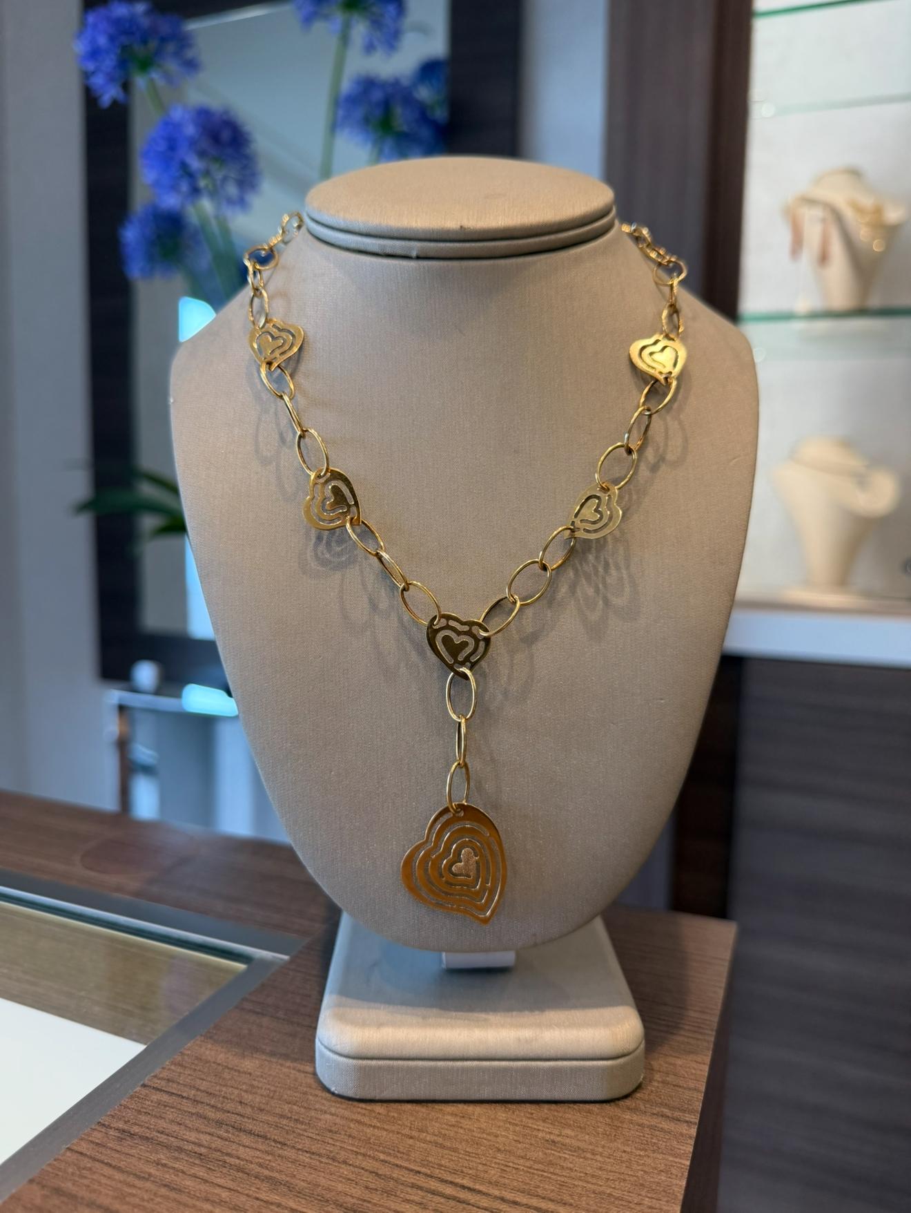 Collier à pendentifs en or jaune 14K avec cœurs et maillons. Le collier mesure 16,5