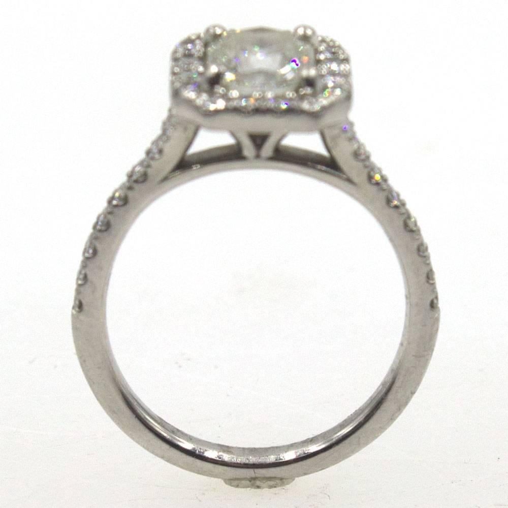 Beautiful diamond engagement ring by Hearts on Fire. The center diamond is an 1.10 carat asscher cut diamond graded I color and SI1 clarity by AGS. The halo platinum mounting features another .30 carat total weight of diamonds. Signed HOF, and