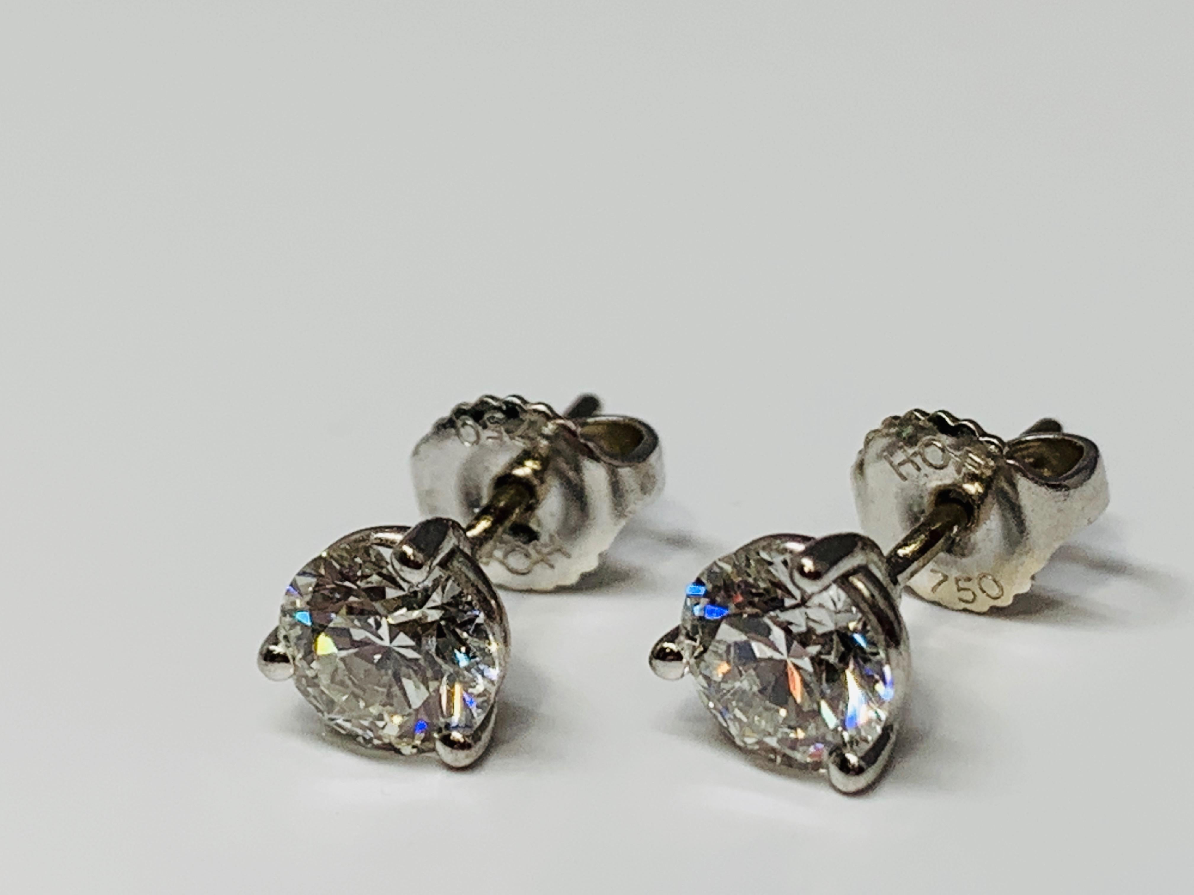 These gorgeous Hearts On Fire diamond earrings are set in a classic 18K white gold 3-prong martini style settings with sturdy tension backs. Each earring holds a fiery 0.75 carat round diamond with an estimated quality of I/VS-SI1. These earrings