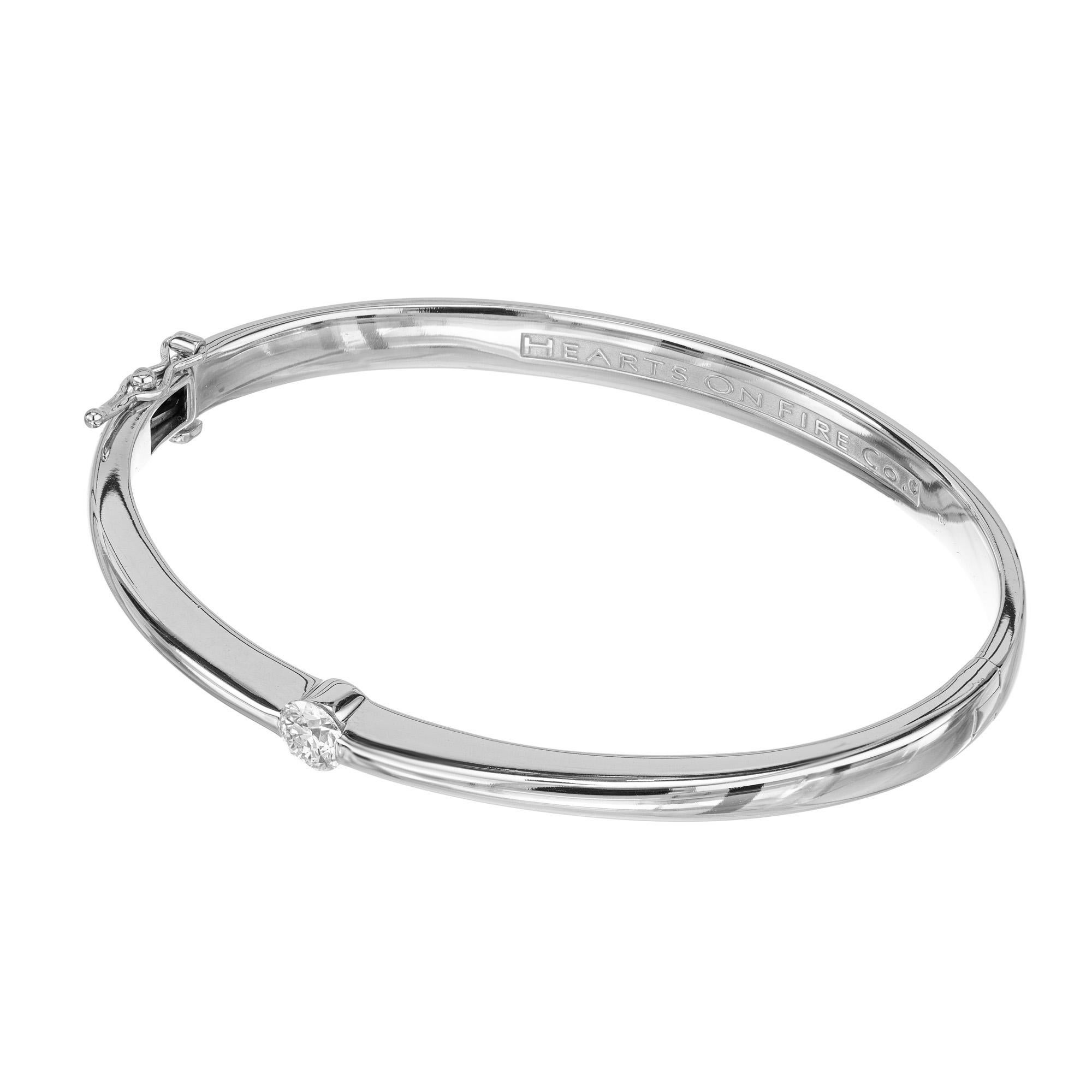 Hearts on Fire classic solitaire diamond bangle bracelet. Crafted to dazzle and delight, the Hearts on Fire is adorned with one .40 Carat round brilliant cut diamond. The oval bangle is created out of 18k white gold and is a true statement piece
