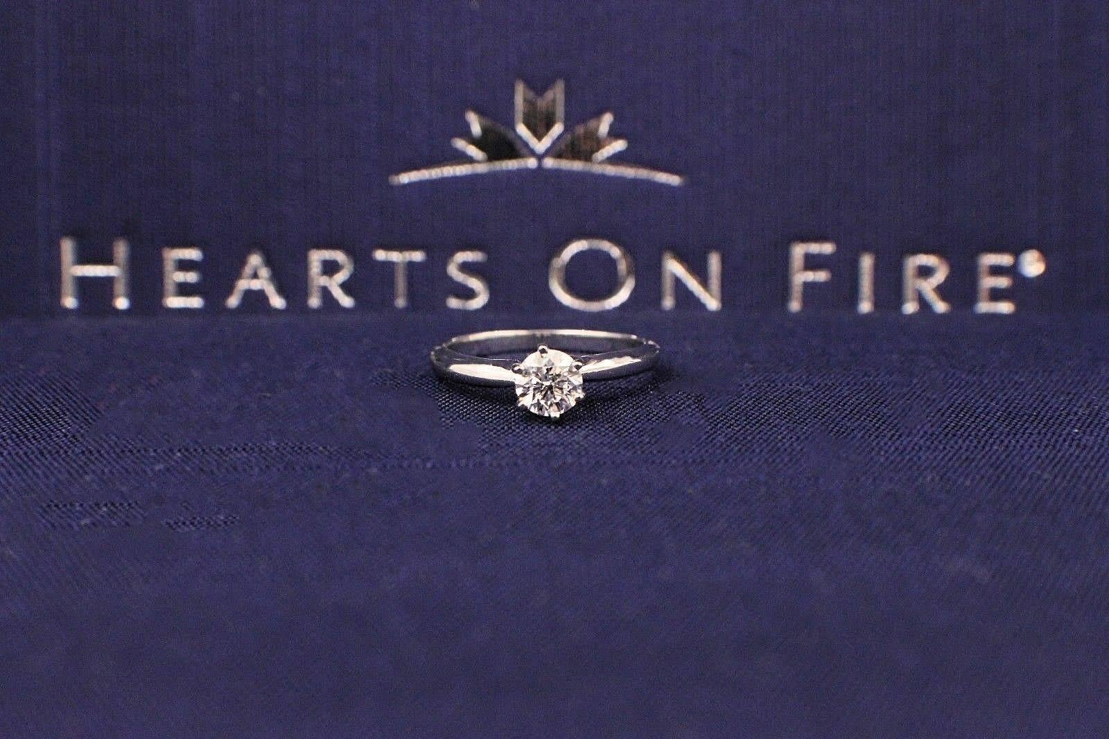 Brand:  HEARTS OF FIRE
Style:  Solitaire Engagement Ring
Serial Number:  0002357803
Metal: White Gold 14KT
Size:  3.75 - sizable
Total Carat Weight:  0.37 CTS
Diamond Shape:  Round Brilliant Ideal Cut 
Diamond Color & Clarity:  G / SI1
Inscription: 