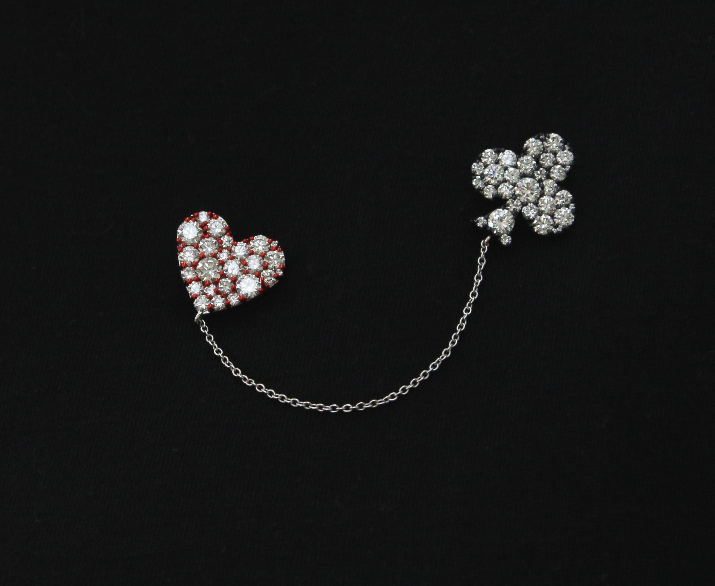 Designed to be worn in any occasion, this Hand-Made White Rose-Cut Diamonds Brooch represents Card Heart & Spade Symbols. 
The 2 Card Symbols are united by a pin-which lays under the dress, and a 18Kt White Gold Chain which stays above.
The Brooch