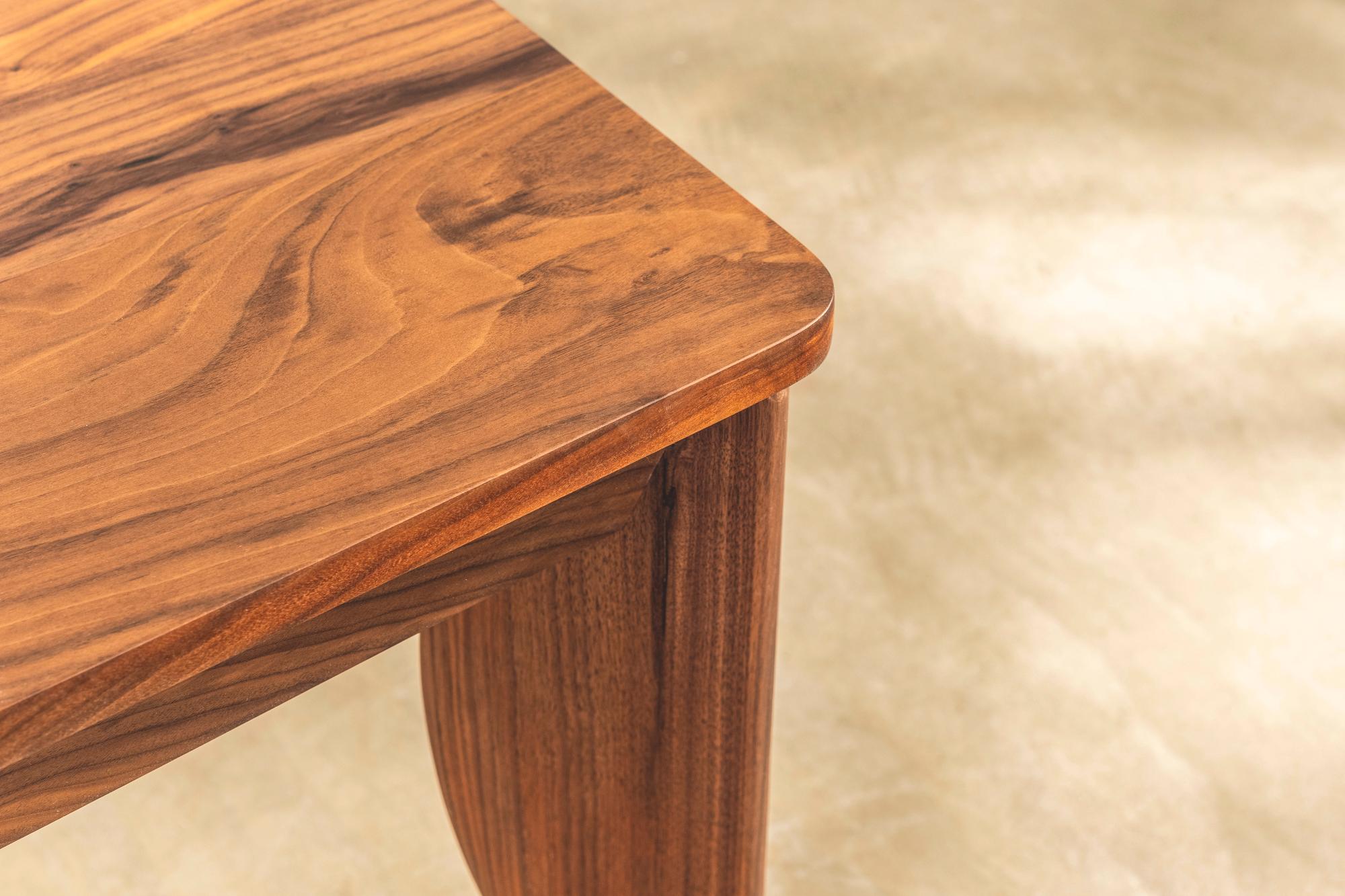 Ein auffälliger Esstisch und ein Satz von sechs Stühlen, entworfen von Terence Conran für den Conran Shop. Der Tisch hat geschwungene Beine aus Nussbaumholz und eine Platte aus massivem Nussbaumholz, die mit einem klaren Öl behandelt wurde. 

Die