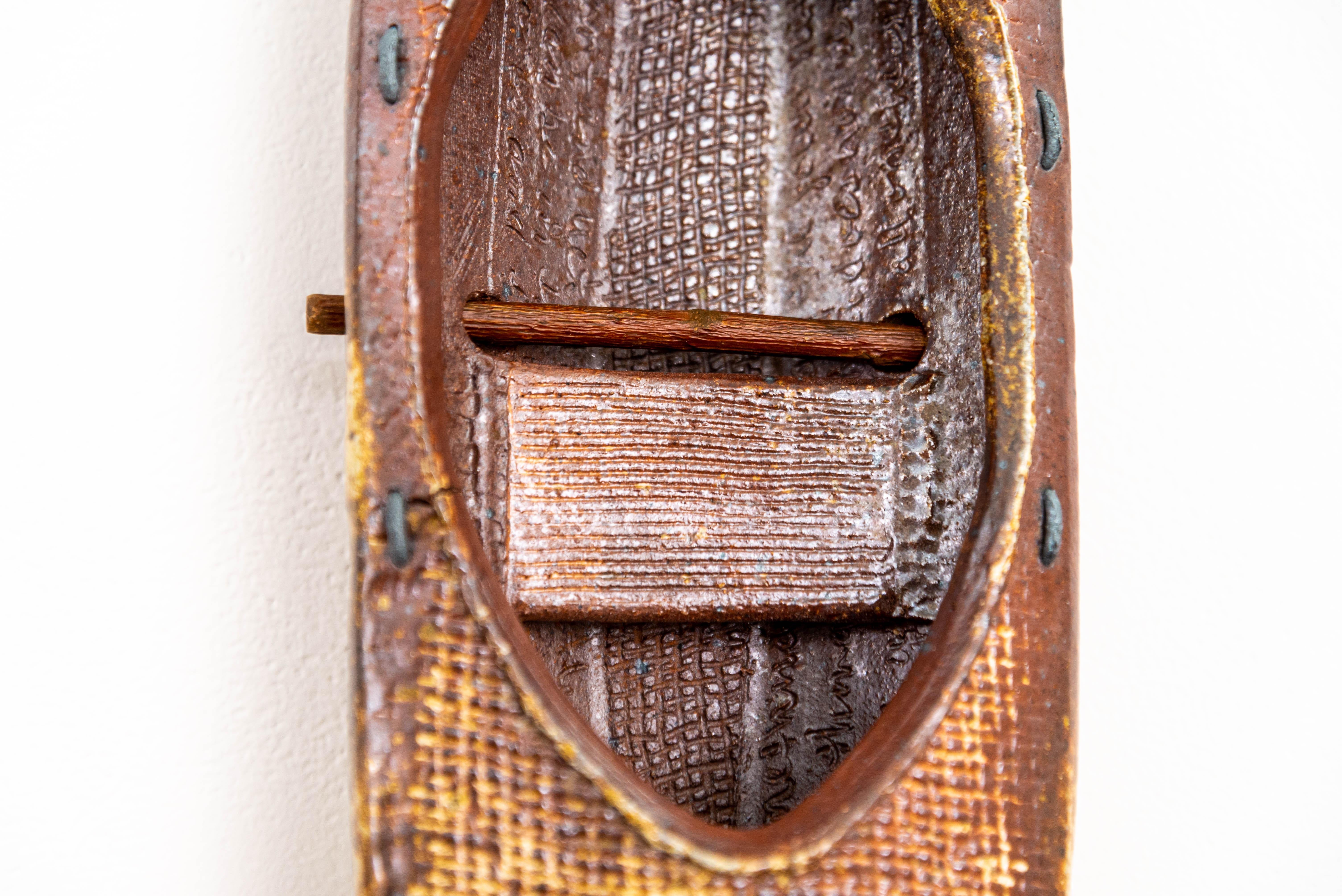This stunning mixed media composition was created by Heather Allen Hietala. The American artist hand-builds canoe-like shapes from clay—this piece features five vessels, each unique in their design. Six paddle-like metal pieces are displayed between
