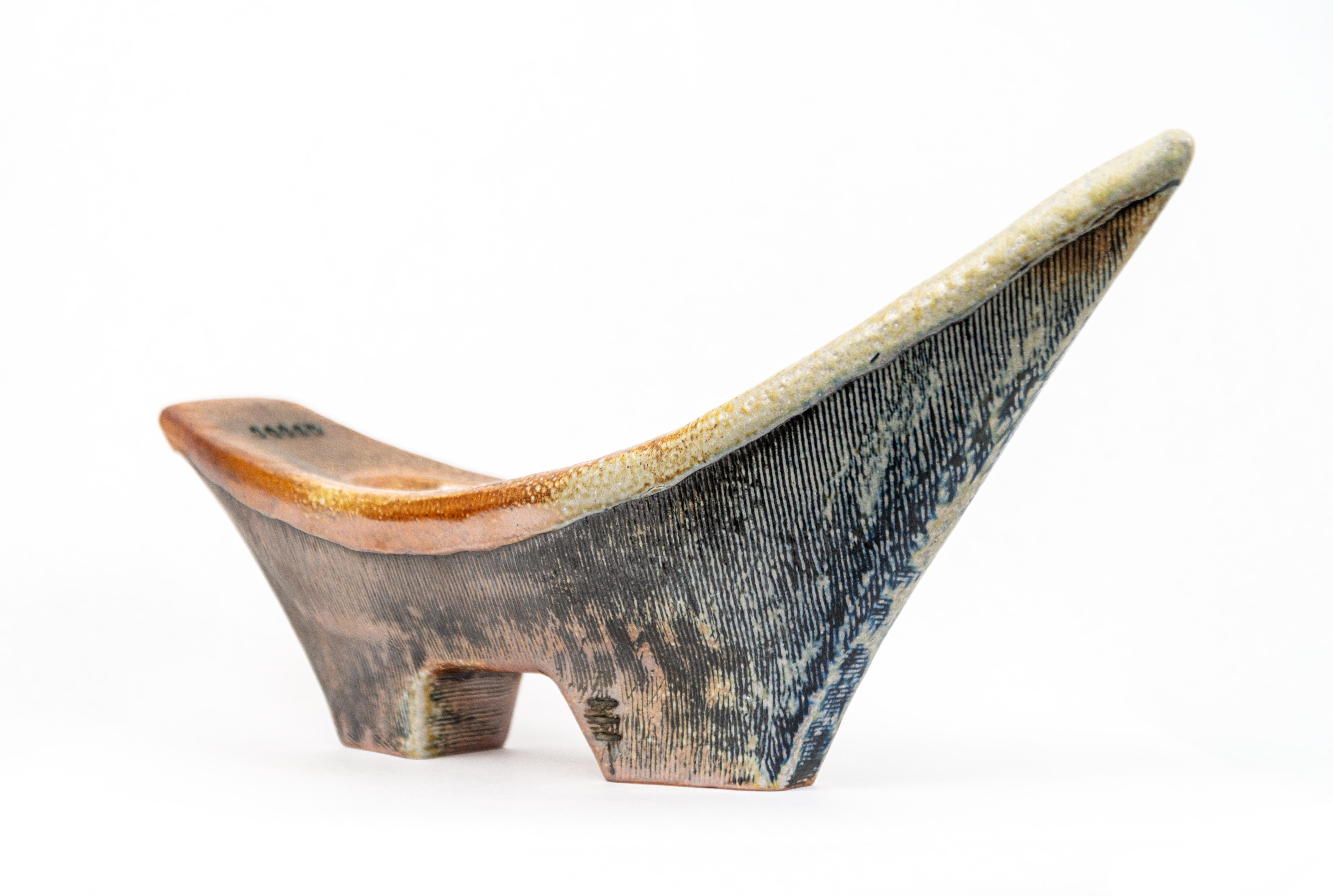 Striking in form, colour and texture, this is one of a new series of clay vessels created by American ceramicist Heather Allen Hietala. The boat-shaped vessel symbolizes life’s journey for the artist. The colour palette is earthy…this one features a