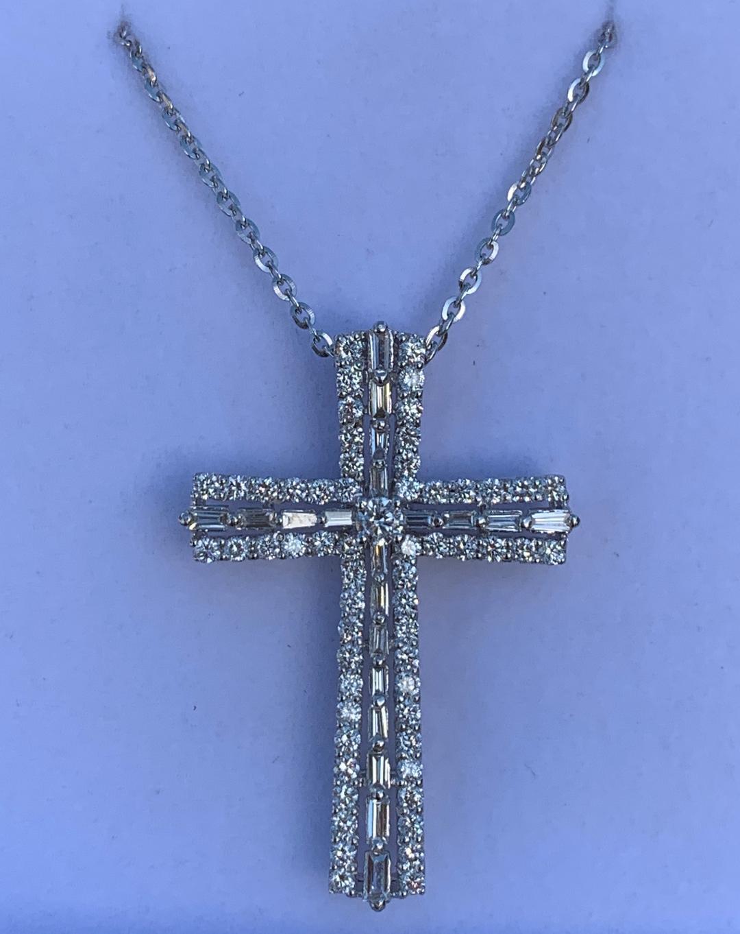 Celebrate your faith in elegant style with this luminous hand made estate diamond cross pendant necklace featuring approximately 1.25 carats of round and baguette cut diamonds, have a heavenly shine in a polished 18 karat white gold setting. Hidden