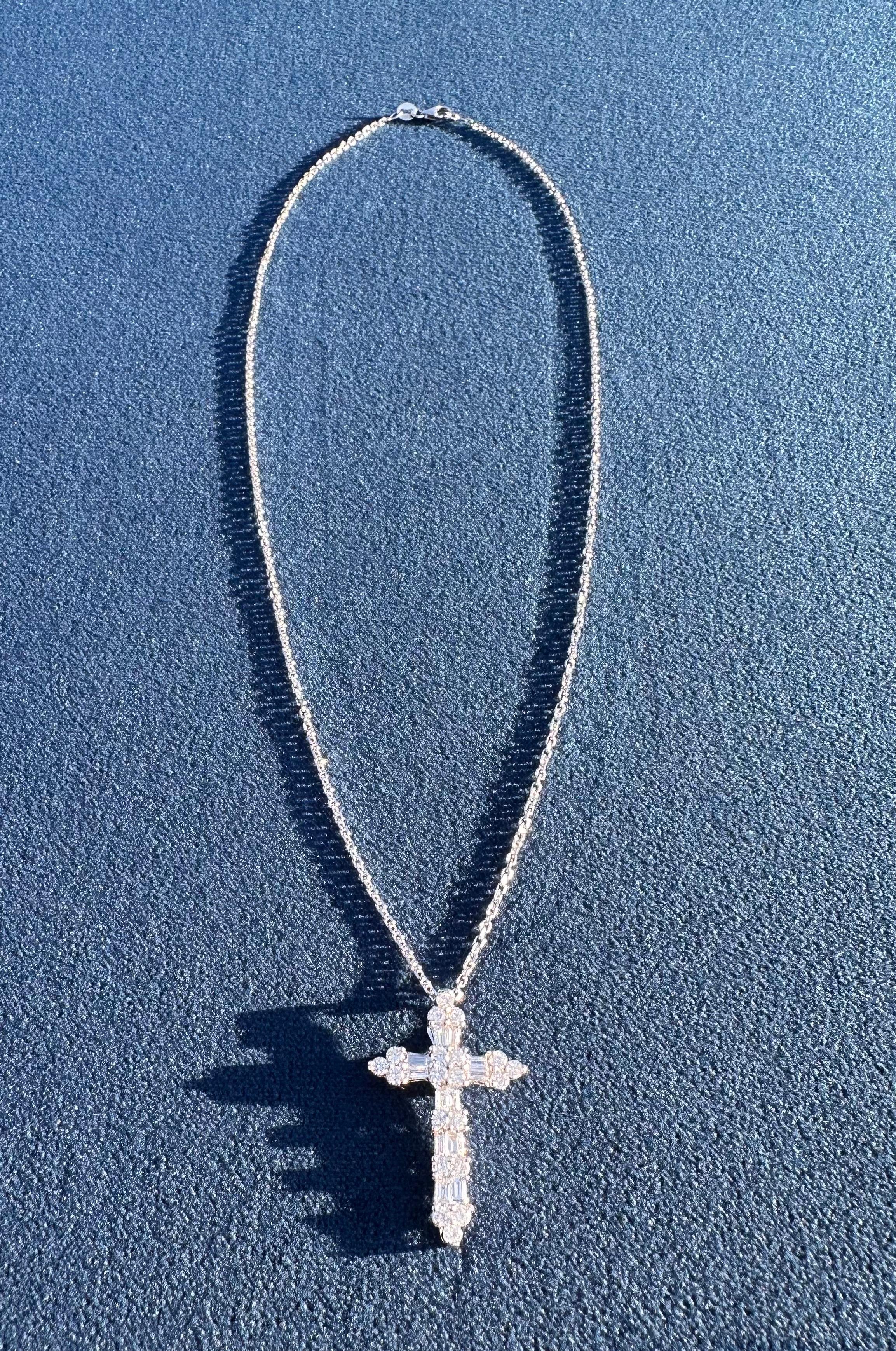Célébrez votre foi dans un style élégant avec ce lumineux collier pendentif croix en diamant fait à la main et composé d'environ 3,50 carats de diamants ronds de taille brillant et baguette.  La croix a un éclat céleste, sertie dans une monture en