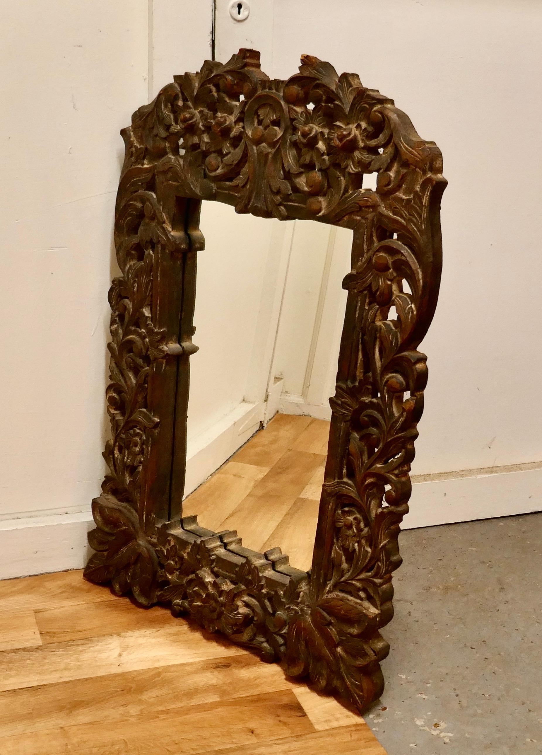 Heavily carved fruitwood mirror.

A lovely piece from the east the 6” wide frame is intricately carved with leaves and fruits, the looking glass is new.
The painted surface of the carved wood was previously painted this is now rather faded with