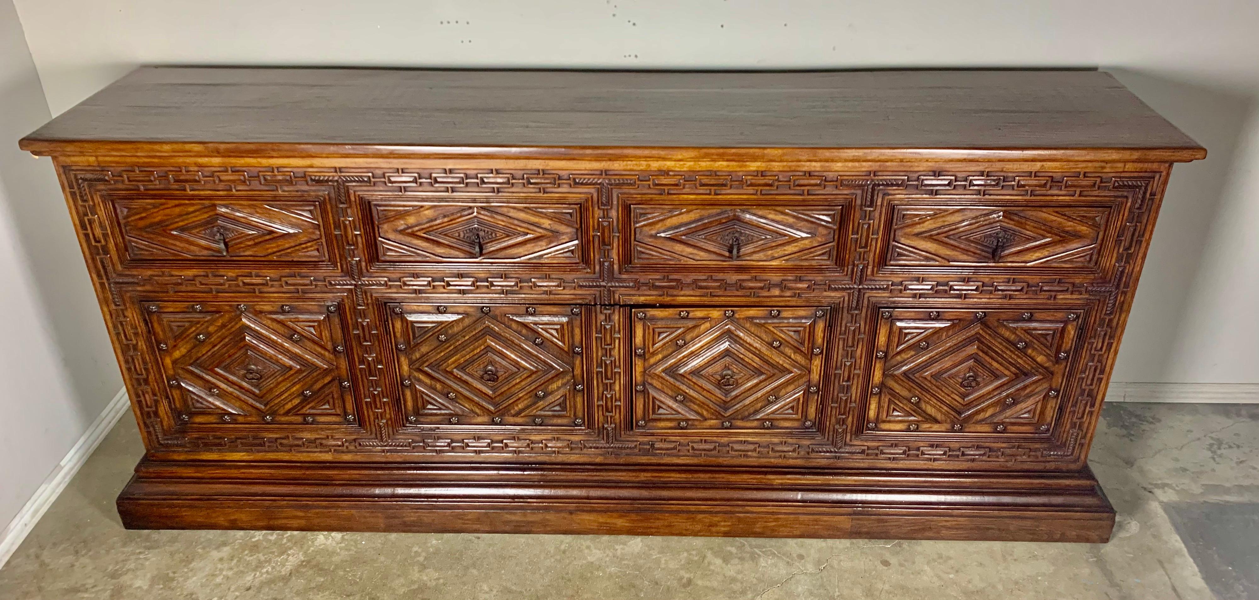 Heavily carved Italian walnut sideboard with great storage underneath including four drawers on top and drawers that were added on the inside of the doors. Iron hardware.