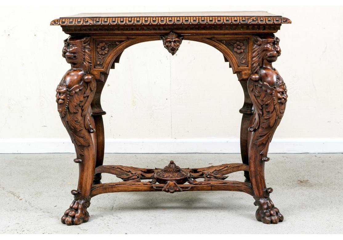 Une table de salon lourdement sculptée avec des bordures en forme d'œuf et de fléchette, un tablier sculpté avec une frise cintrée avec des masques. La table est soutenue par quatre supports figuratifs détaillés joints à un châssis élaboré avec des