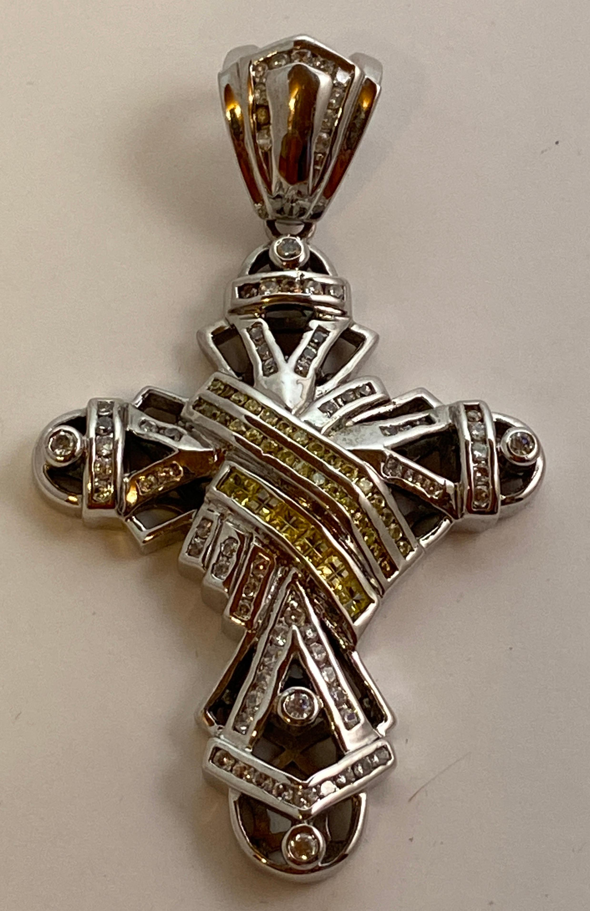 This heavily plated white gold pendant is accented with semi precious stones. The center is accented with yellow semi-precious stones. The total length measures 3 1/4 inches. the width measures 2 inches. Depth measures 3/8 of a inch. Made in US.