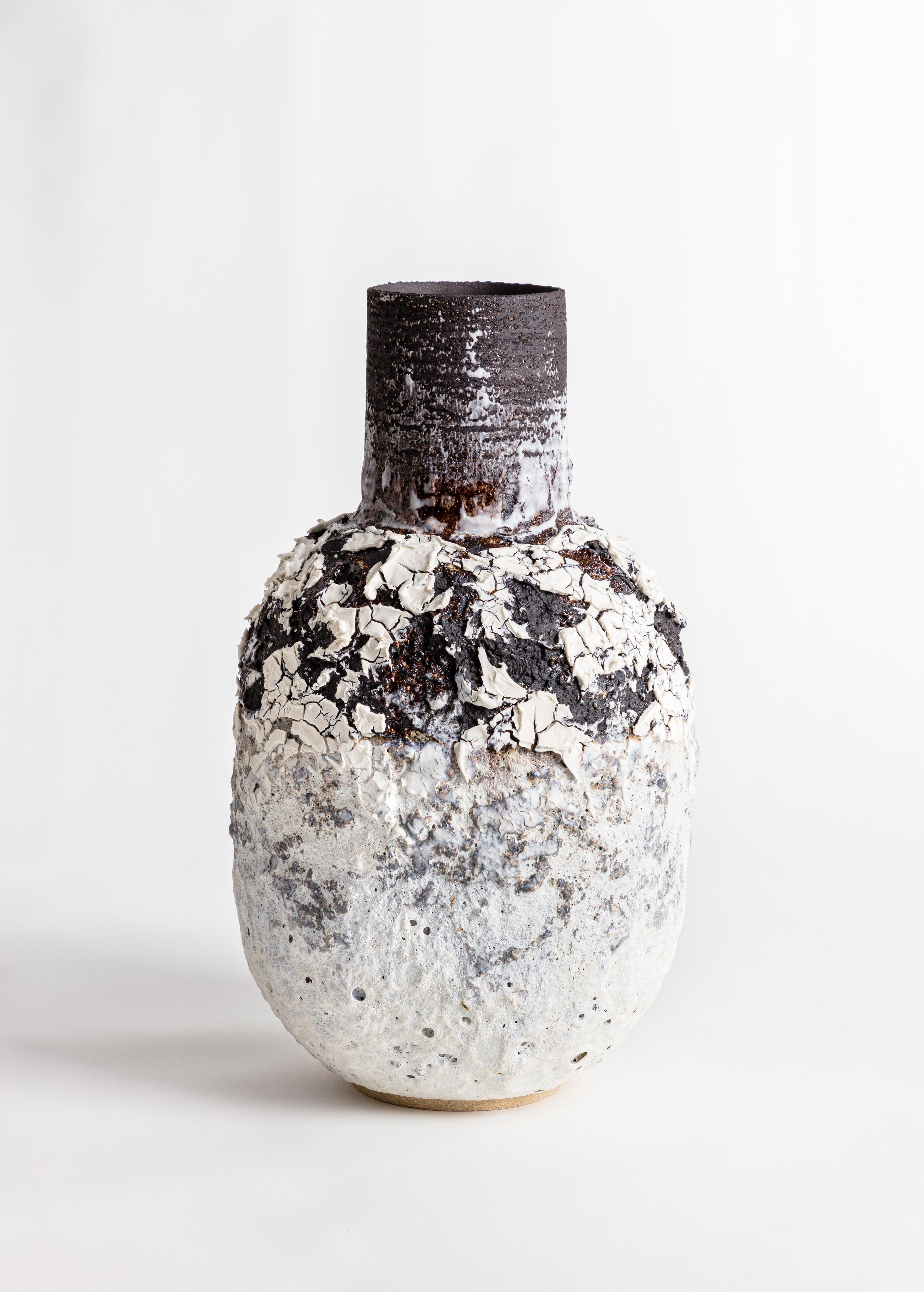 Un grande vaso a forma di bottiglia vulcanica fortemente strutturata con smalti e marcature in bianco e nero. Realizzato in gres nero e ingobbio di porcellana.

L'ispirazione per il pezzo viene dall'argilla stessa e dalle relazioni chimiche che lo