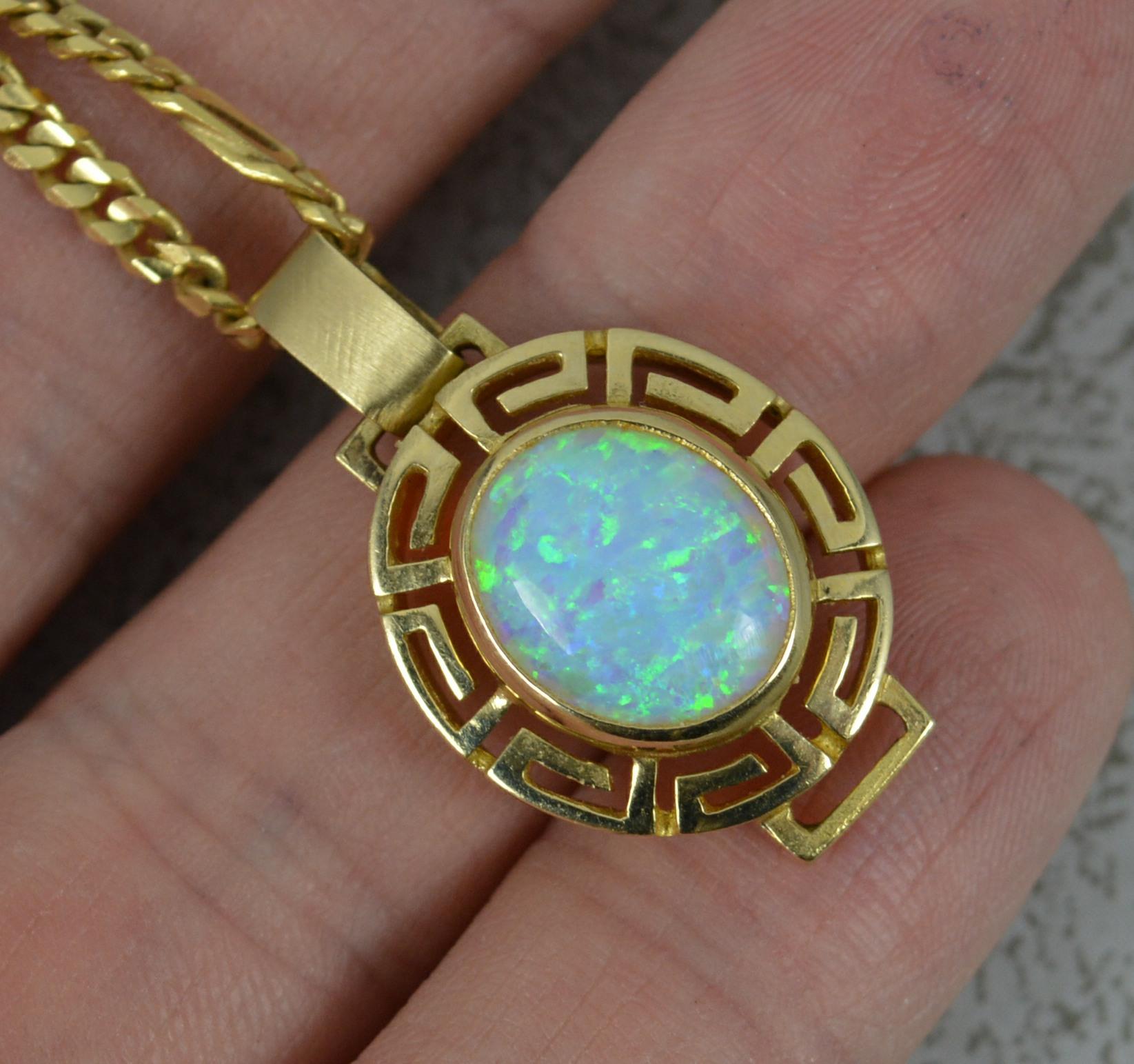 A superb 14 carat gold and opal pendant.
Large and colourful opal composite stone to centre with Greek pierced design gold border.
Complete with long fine curb link chain. 

Condition ; Excellent. Crisp design. Issue free.

Please view photographs