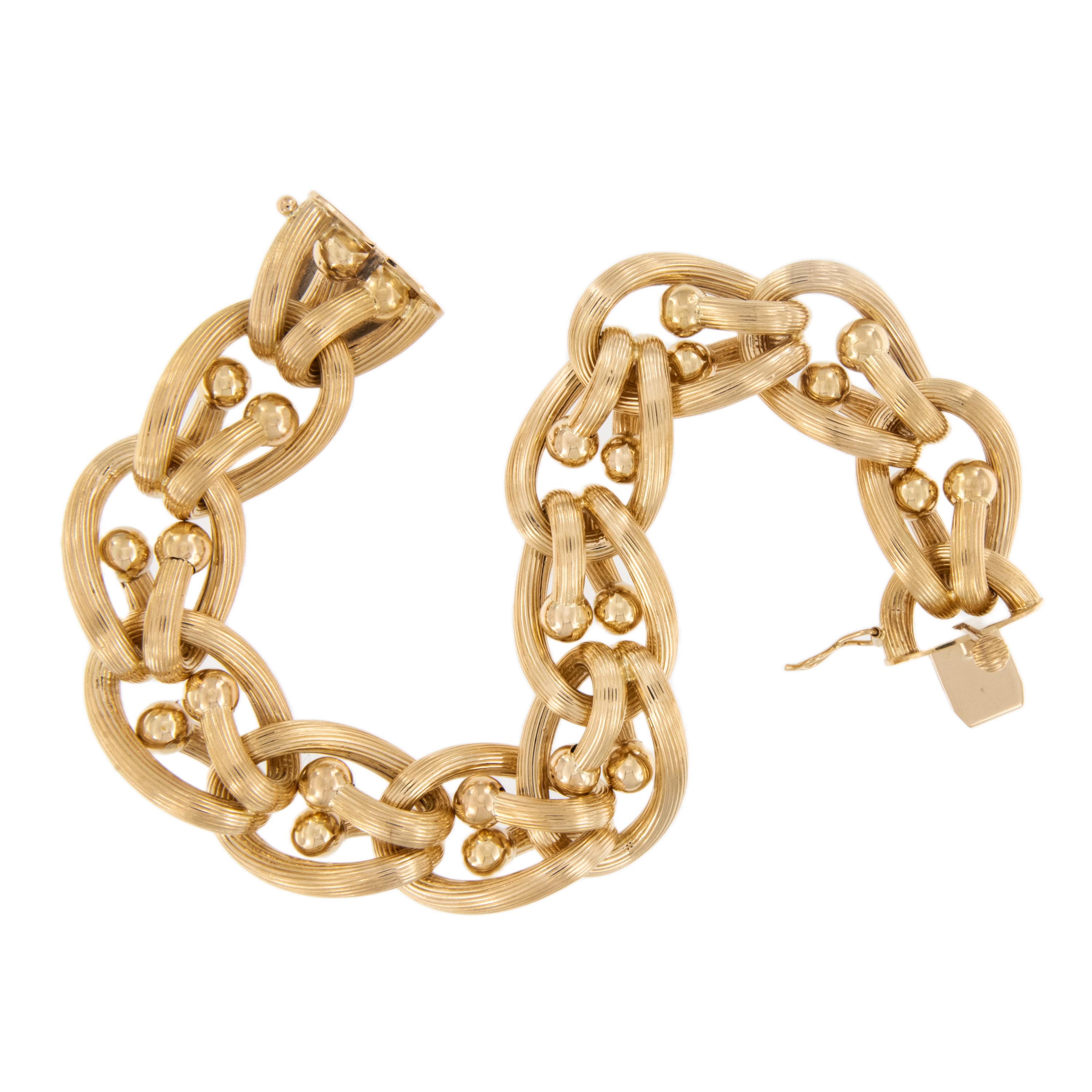 This eye catching bracelet is comprised of 18 karat yellow gold with ribbed, oval loop through with ball ends for a bold, fashionable look! You will get a boost of confidence from the moment you put it on your wrist! Bracelet is 8.5