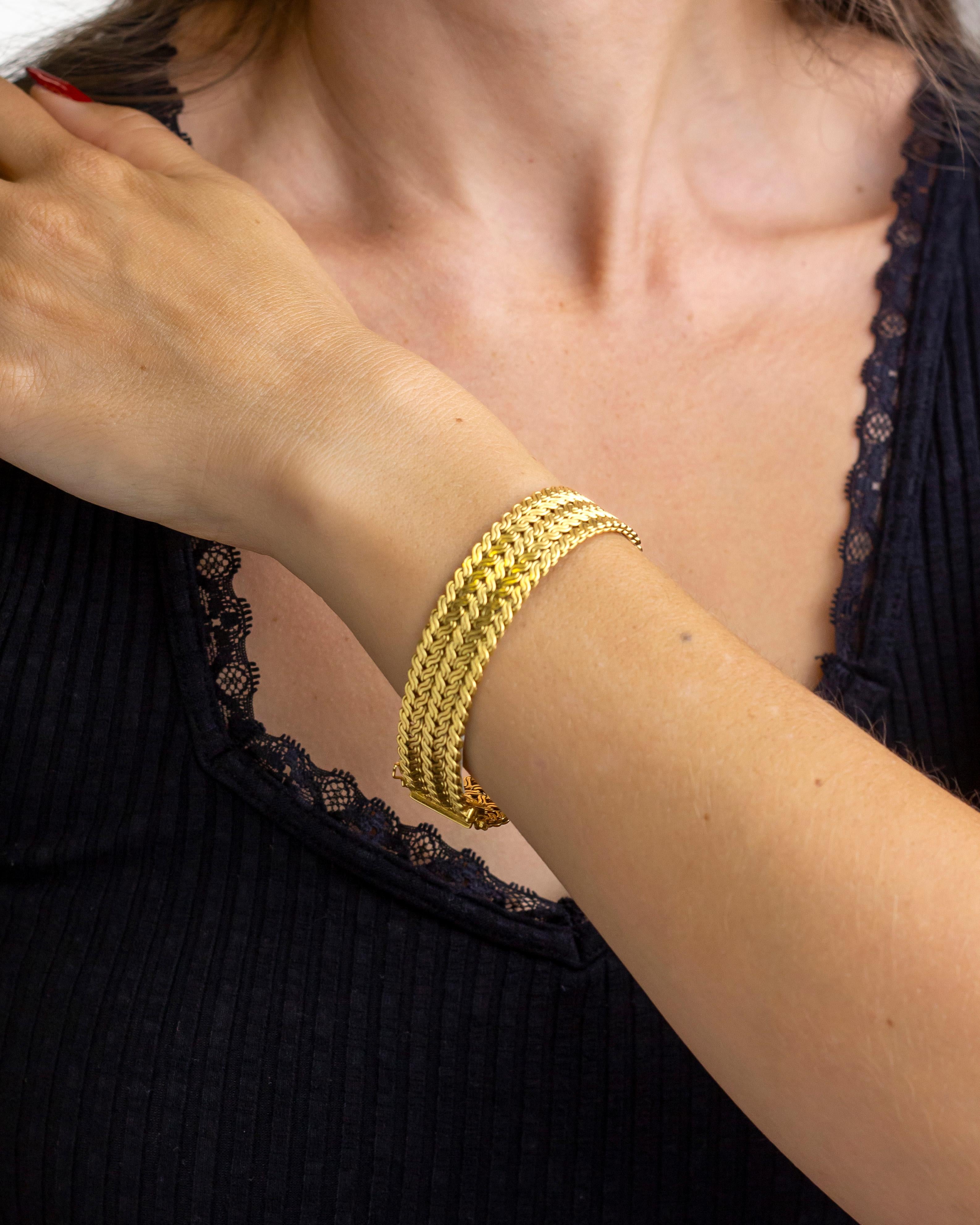 This hefty bracelet has been manufactured from 18 karat gold, likely in the second half of the 20th Century. The bracelet which has a woven like appearance features and tongue and box clasp which is working well, along with two figure of 8 safety