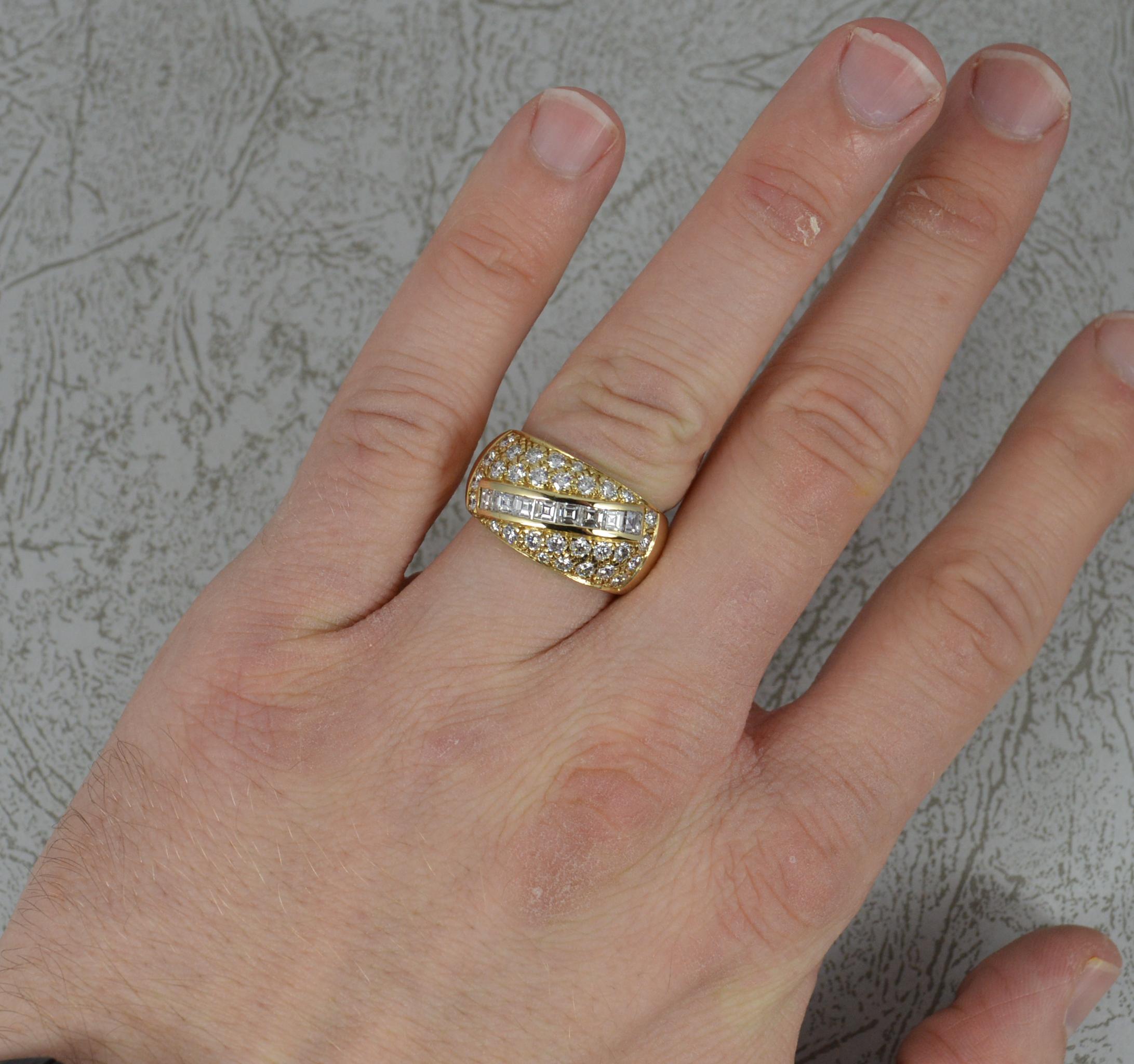 Ein sehr auffälliger Ring aus 14 Karat Gold und Diamanten.
Ein größerer, bombenartiger, geglätteter Clusterkopf.
Bestehend aus vielen natürlichen Diamanten mit einer diagonalen Linie aus Diamanten im Karree-Schliff und vielen runden Diamanten im