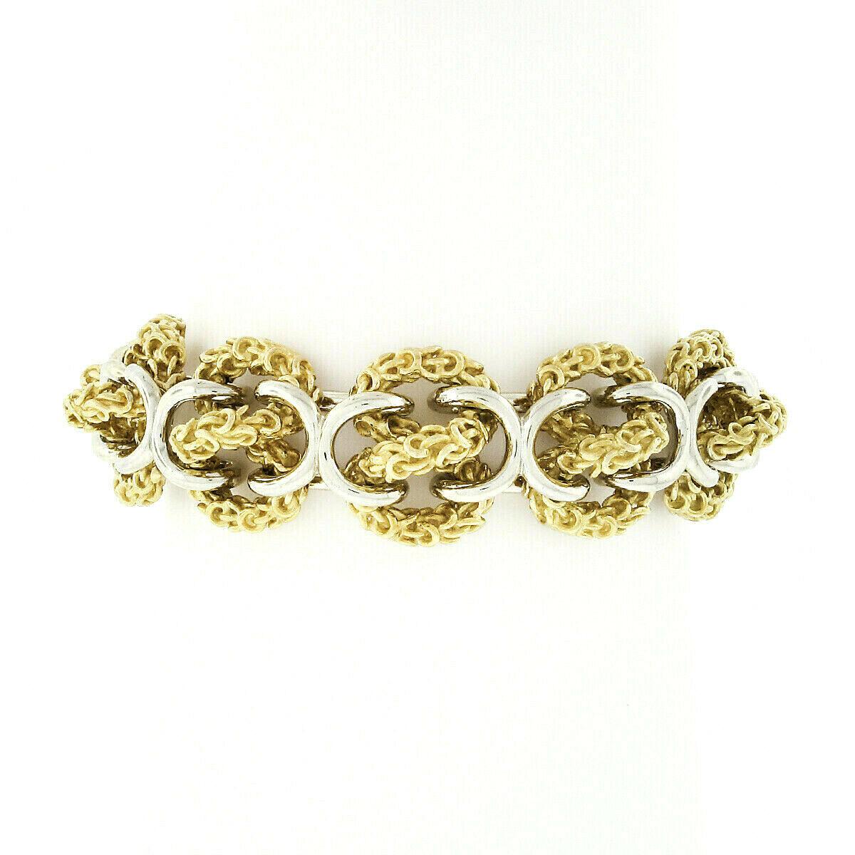 Voici un remarquable bracelet vintage à maillons avec nœud à l'infini en 3D, fabriqué en Italie à partir d'or jaune et blanc 18 carats. Les nœuds à l'infini en or jaune du bracelet sont d'une texture complexe et sont soigneusement reliés à de gros