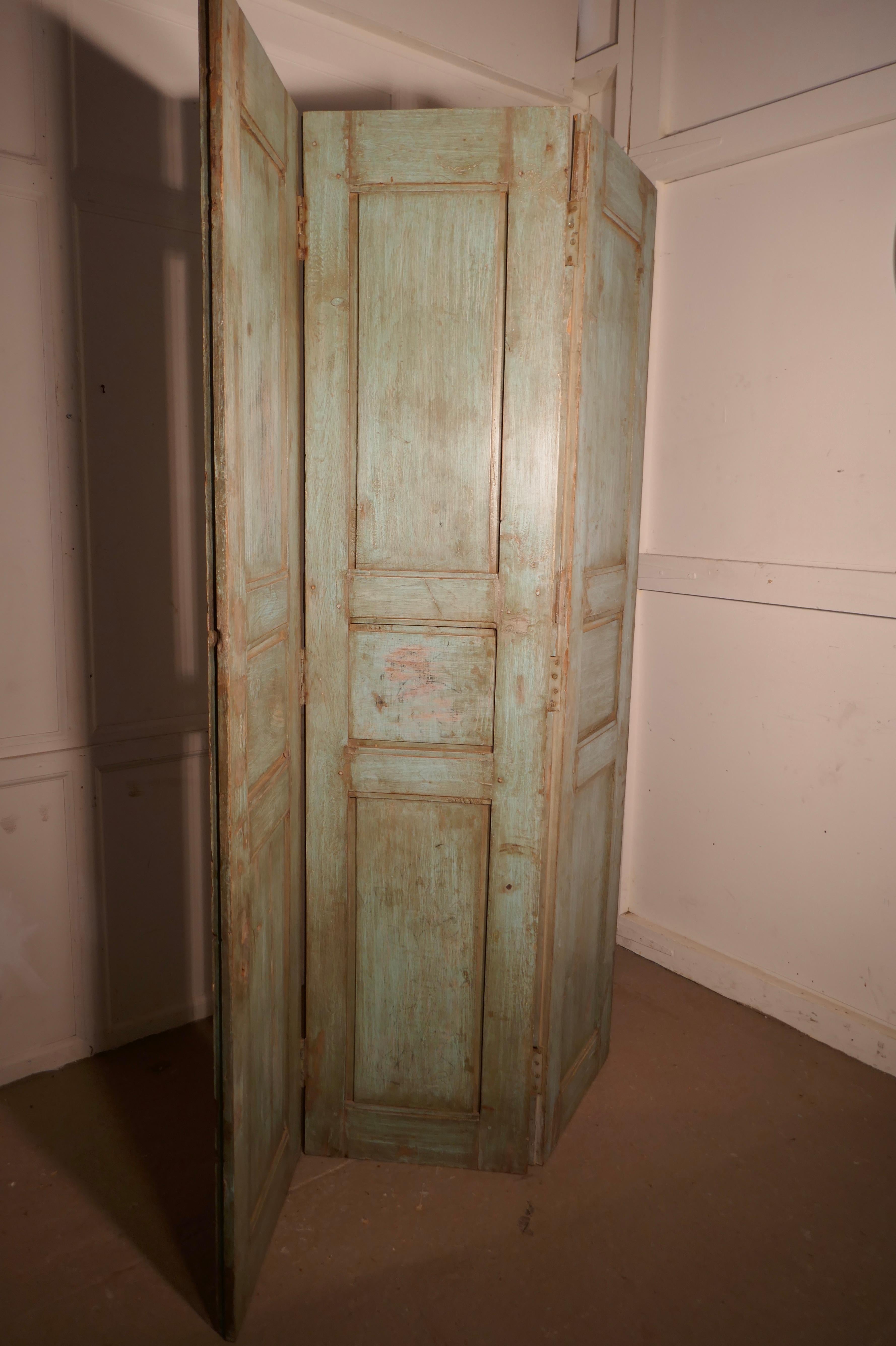 Heavy 19th century painted French window shutter 3 fold screen, room divider

This is a very heavy piece, the screen is 3 hard wood shutters which are in their original distressed paint, on a light blue green shade
The room divider has 3 panelled