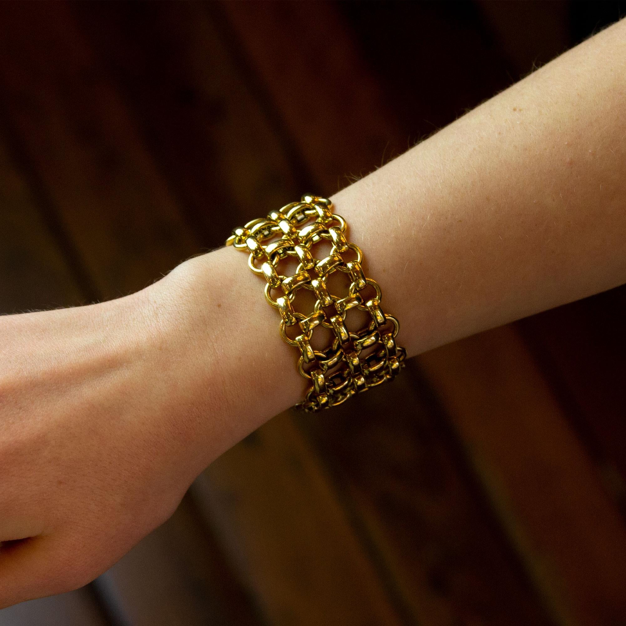 Un audacieux bracelet à maillons fantaisie en or jaune 18 carats dans un style en treillis. La pièce, d'un poids incroyable, se compose de maillons ovales en or de type belcher et de maillons ronds en fil d'or interconnectés pour former un treillis.