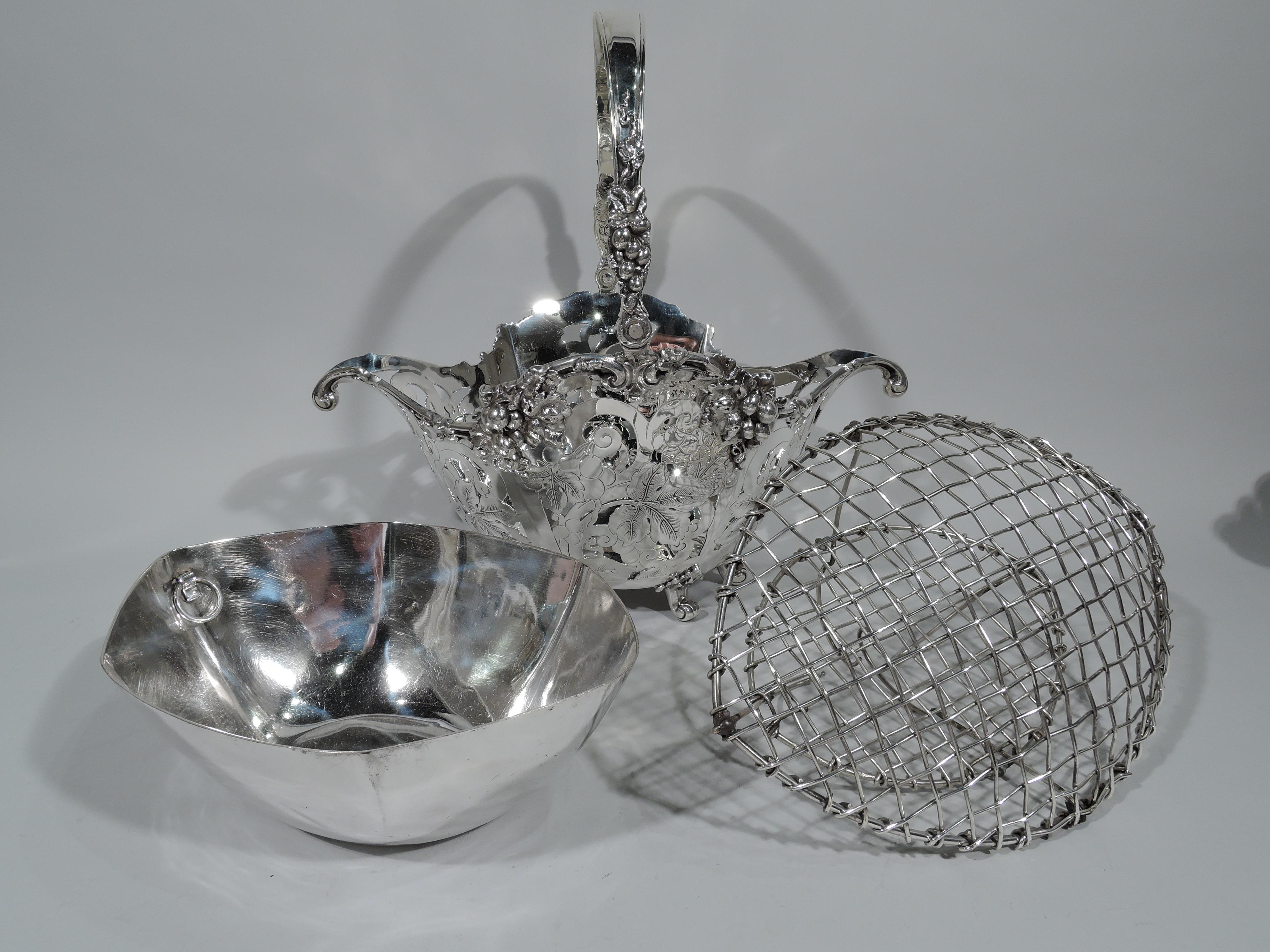 Edwardian sterling silver basket. Made by Tiffany & Co. in New York, circa 1904. Ovoid with tapering sides, scrolled rim, and scrolled rim. Six leaf-mounted scroll supports and c-scroll swing handle. Pierced scrolls, engraved leaves, and applied