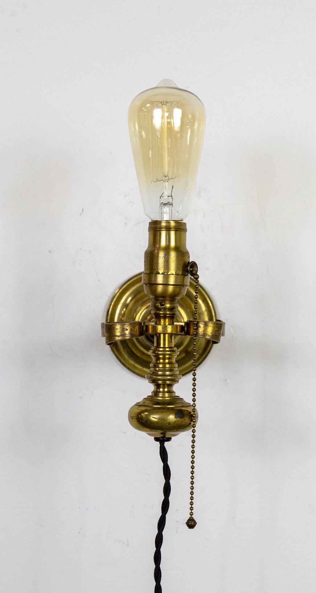 A nautical, candlestick style wall lamp made to rock on a ship and stay upright. An interesting piece of history from the late 19th century. It looks great as a table lamp too. Newly wired with a fabric covered, rope cord; pull chain switch. Medium