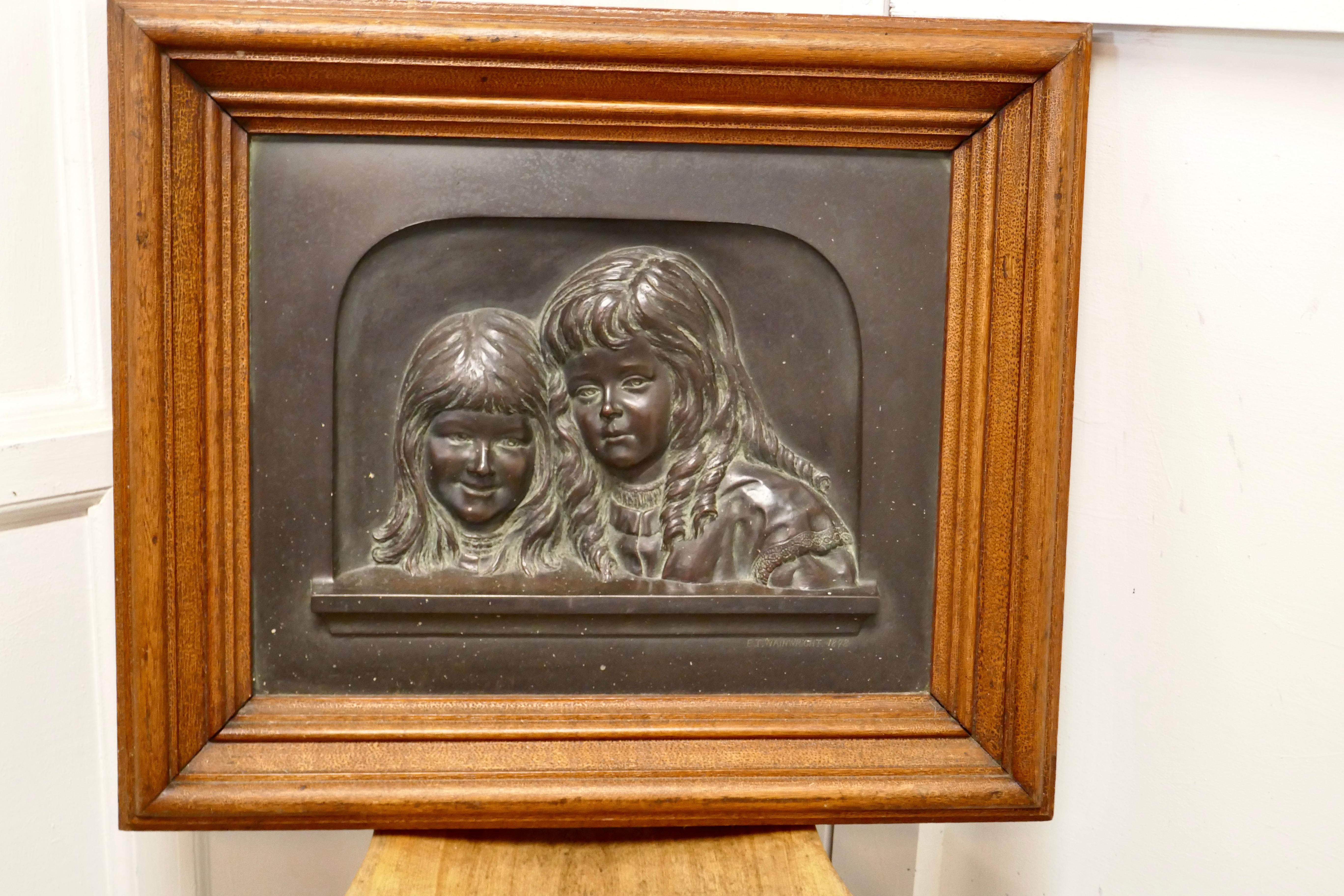 Heavy bronze relief wall plaque, “Sisters” by E T Wainwright 1898

An exceptional bronze plaque, set in its original 4” wide purpose made Oak Frame with iron hanging brackets 
The subjects are 2 smiling girls, a lovely piece in good condition