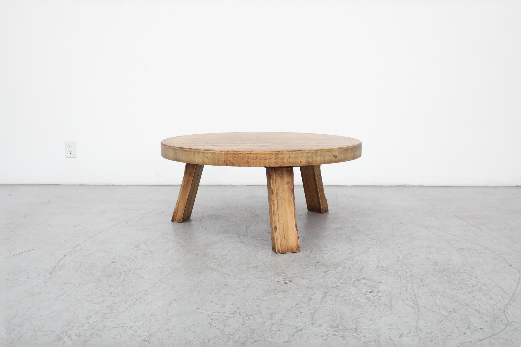Round, Mid-Century Brutalist Pierre Chapo inspired coffee or side table made from solid wood with three sturdy square legs. In original condition with visible wear and patina consistent with its age and use. Other similar tables available and listed