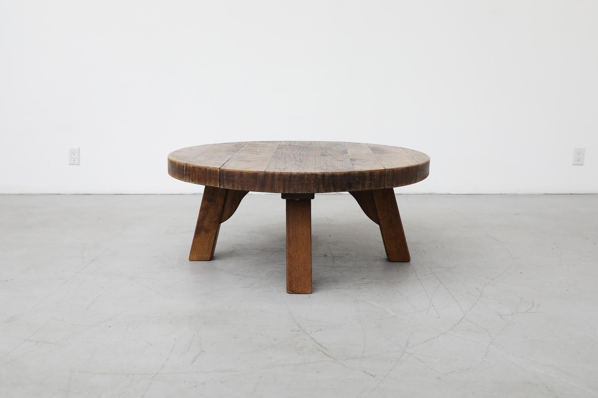 Heavy Pierre Chapo style round Brutalist coffee table is made from solid oak and has three sturdy square legs. In original condition with visible wear and patina consistent with its age and use.