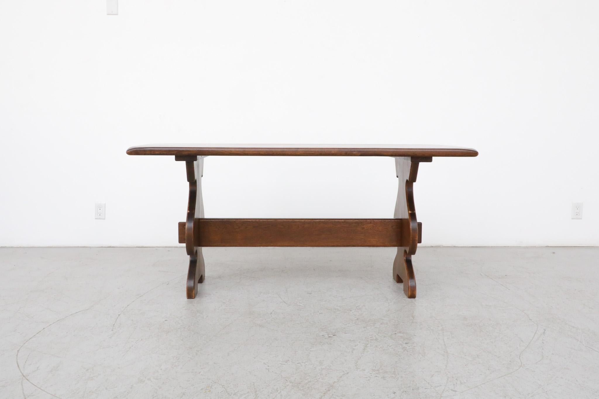 Organically shaped, hand-carved, heavy oak dining table or desk with decoratively hewn trestle base. In original condition with some visible wear true to its age and use. Similar Göran Malmvall dining set also available & listed separately