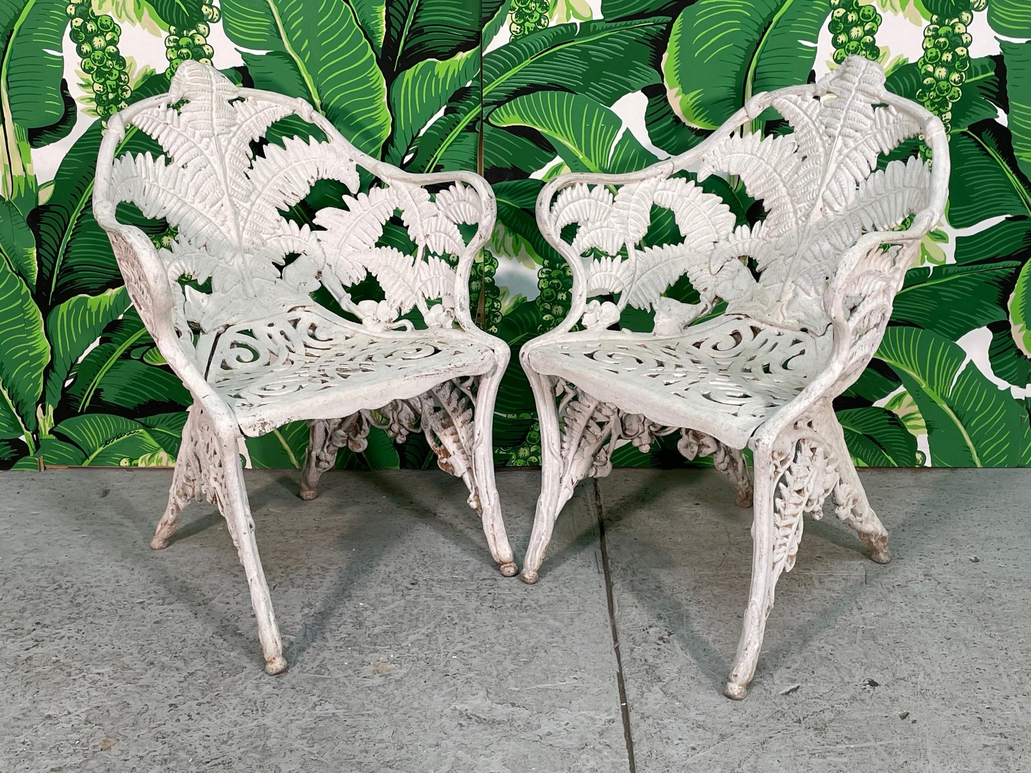 Pair of heavy cast iron patio chairs in a open form with fern leaf design. Could be cast aluminum, but each weighs over 50 pounds. Good vintage condition with typical wear consistent with age (see photos). Seat height is 16,5